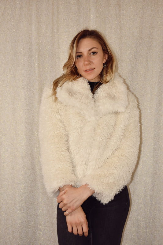 faux fur coat with floppy oversized collar and one snap enclosure on front. waist length and sleeves arent completely full length. has pockets.