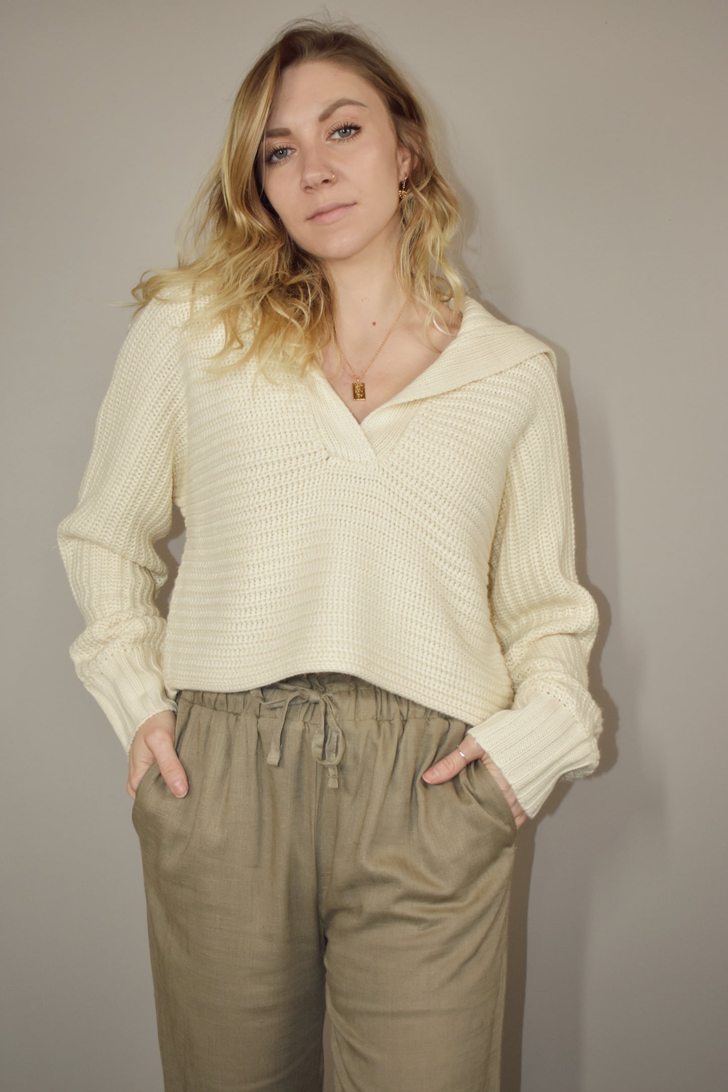 knit slouchy cropped sweater with a v neck that goes into a fabric flap collar that drapes over your back and shoulders.