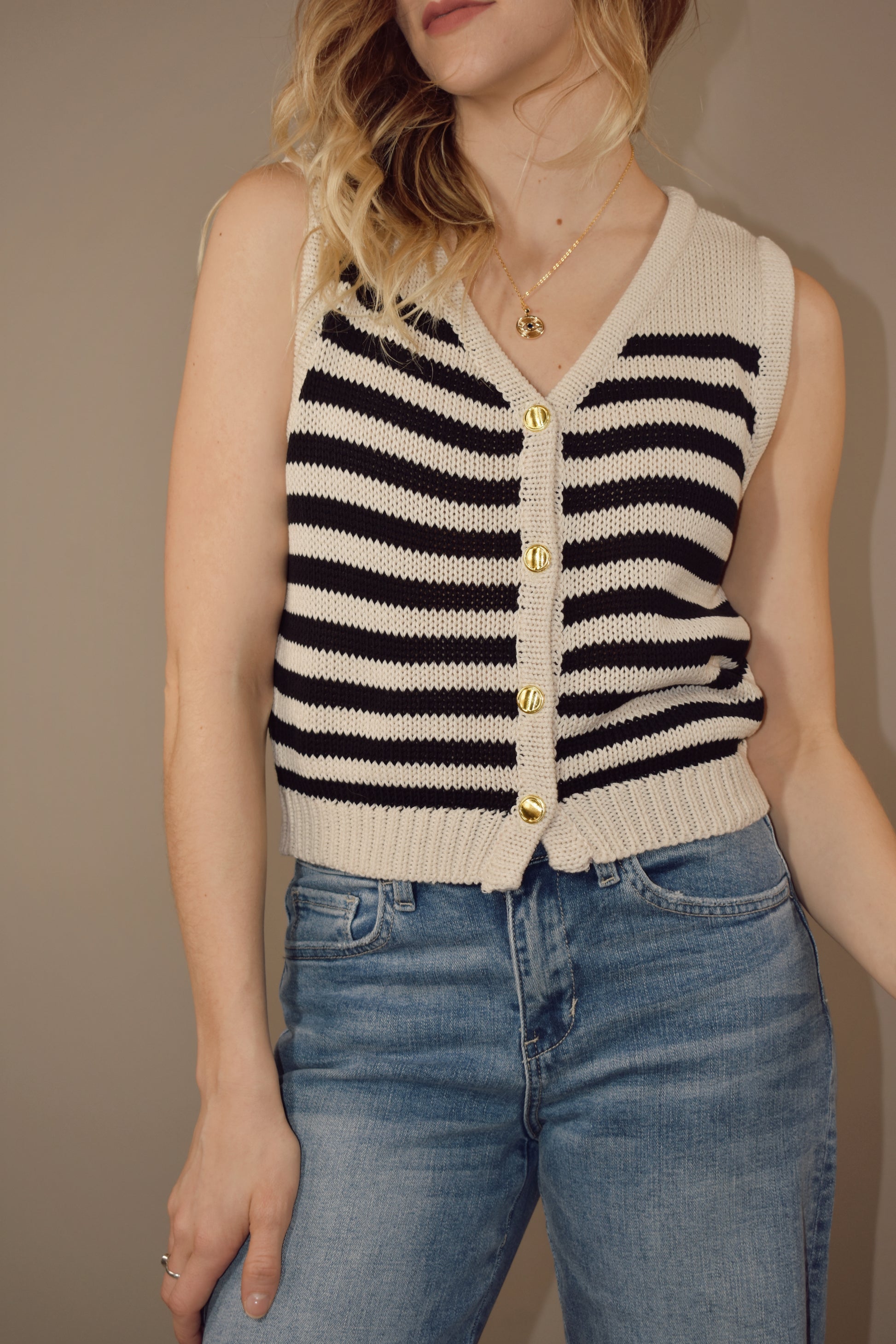 striped v neck sweater vest that has gold buttons down the front