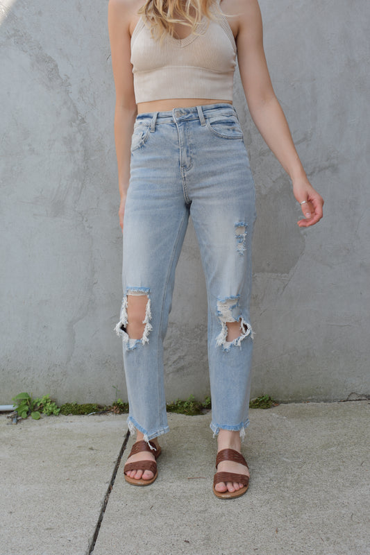 high rise stretch denim. ankle length with distressed hem. holes at the knees and distressing. straight fit. light wash.