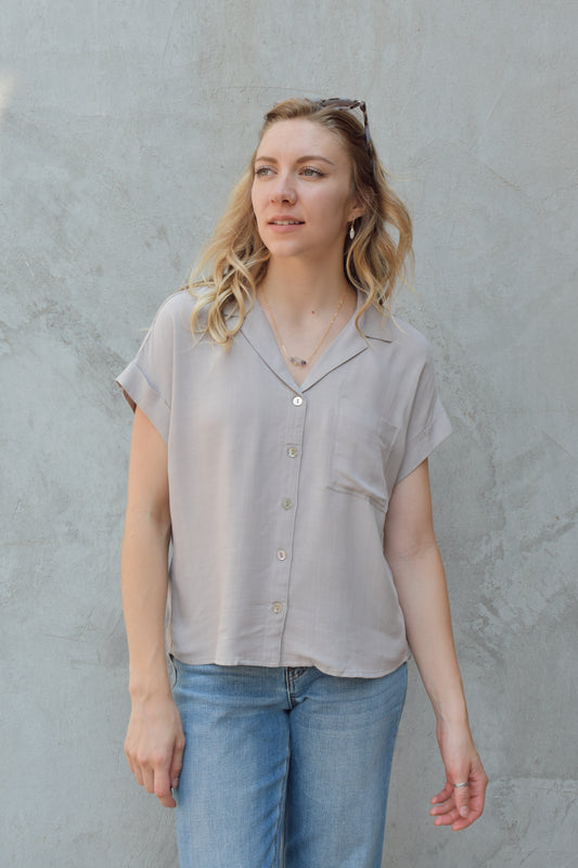 short sleeve button down with cuffed sleeves, v neckline, metallic buttons, full length, relaxed fit, one breast pocket, lightweight.