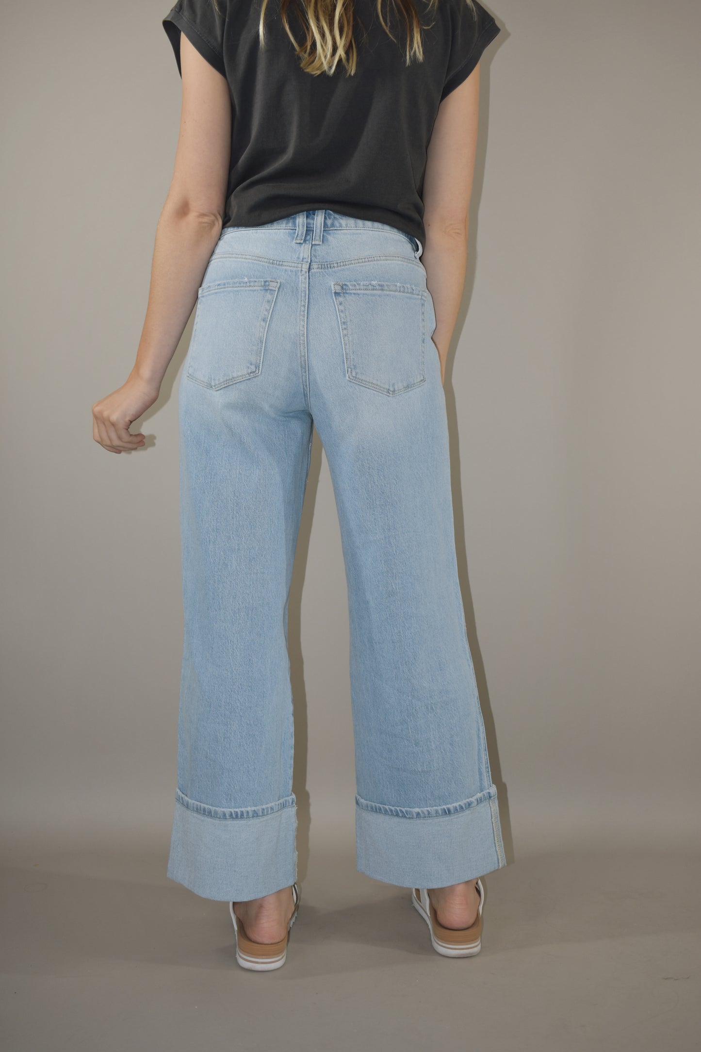 light wash wide leg jeans with large cuff at the hem. no holes or distress marks. double pocket feature in front. stretch denim. has beltloops and back pockets and a zip and button enclosure. high rise. 