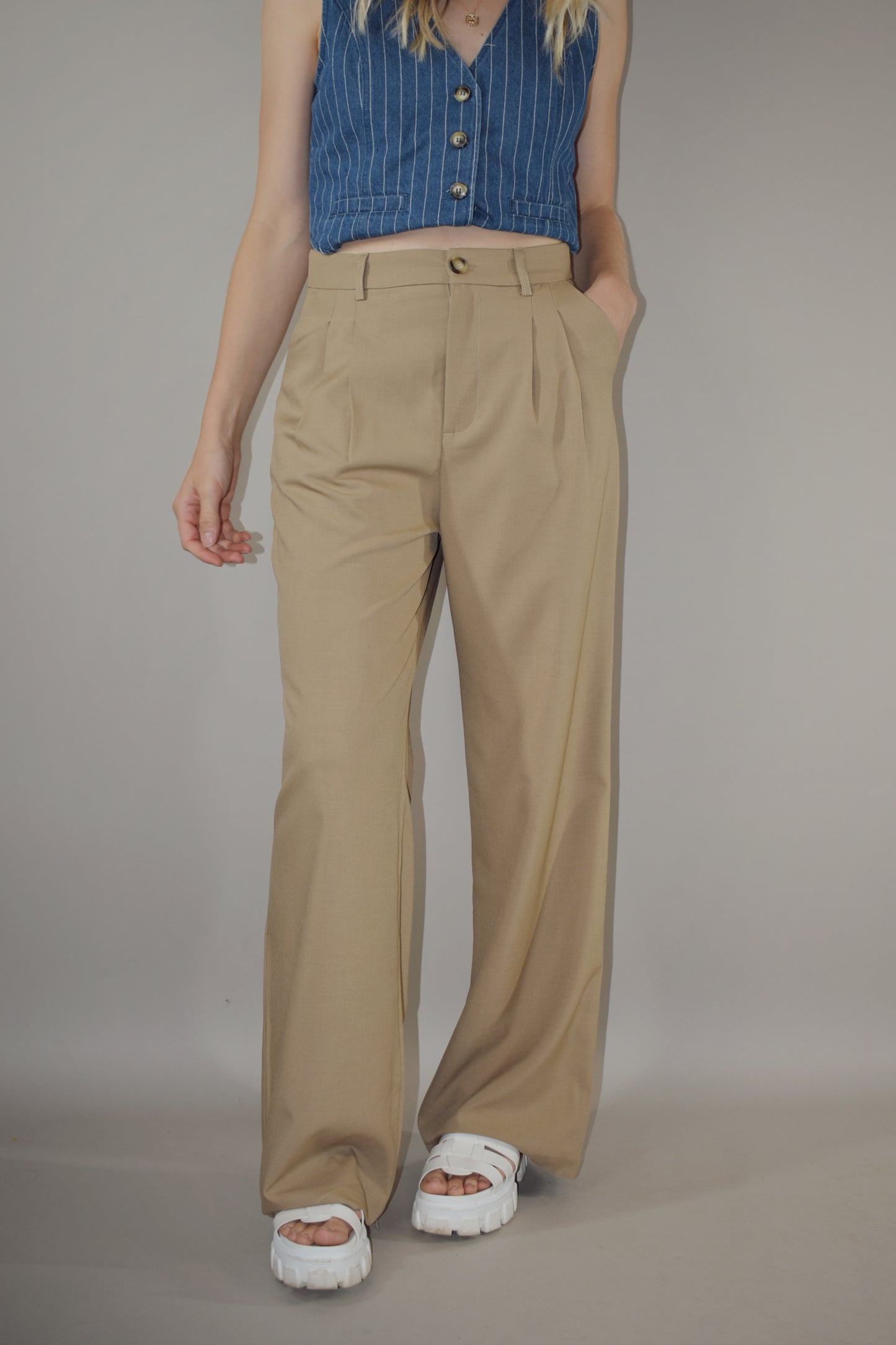 straight leg trousers with a slight baggy look. pleated with pockets and full length. length runs a little long. back doesn't have real pockets. pants have beltloops and a zip and button enclosure.