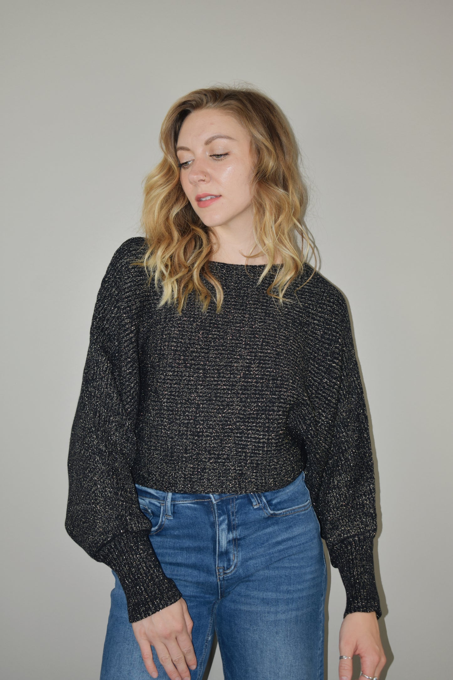 cropped sweater with a boat neckline and bubble sleeves with long ribbed cuffs. sparkles woven into the stretchy fabric. bat wing sleeve effect as well.