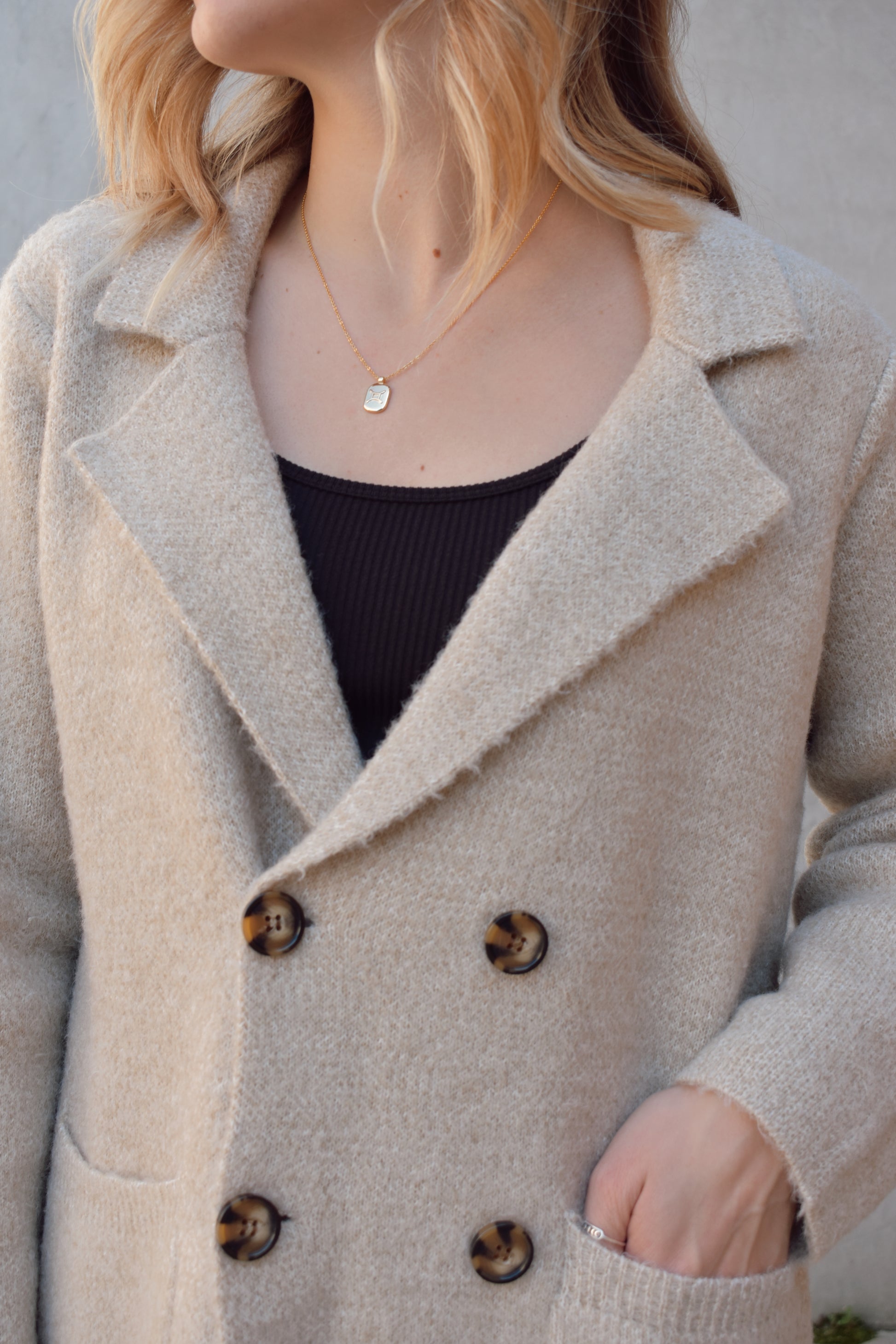 longer sweater coat style cardigan double breasted with patch pockets. brown buttons. slightly oversized.