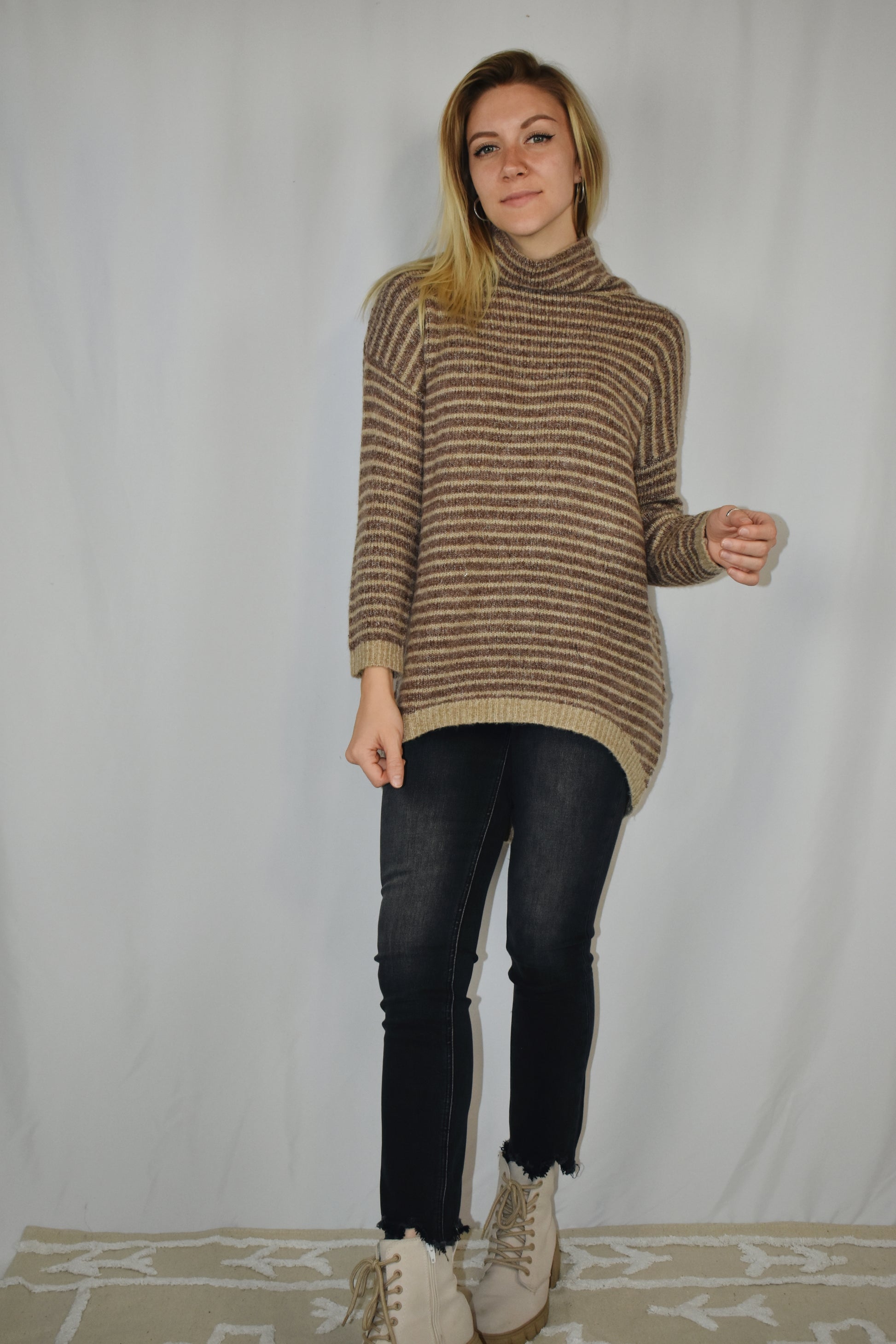 Pullover turtleneck striped sweater. Drop shoulder long sleeves, ribbed hem and sleeve cuffs, and high-low rounded hem. Dark mocha and taupe color.