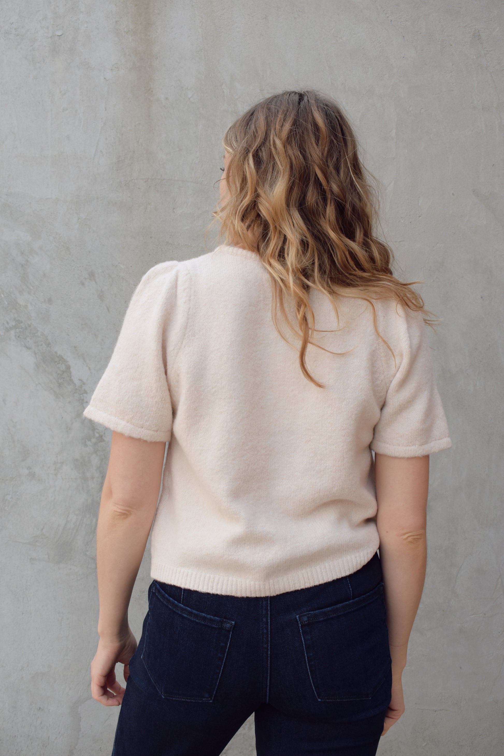 short sleeve cardigan sweater with crew neckline and slight puff sleeves gathered at shoulder, ribbed hem, straight fit, hits at waistline