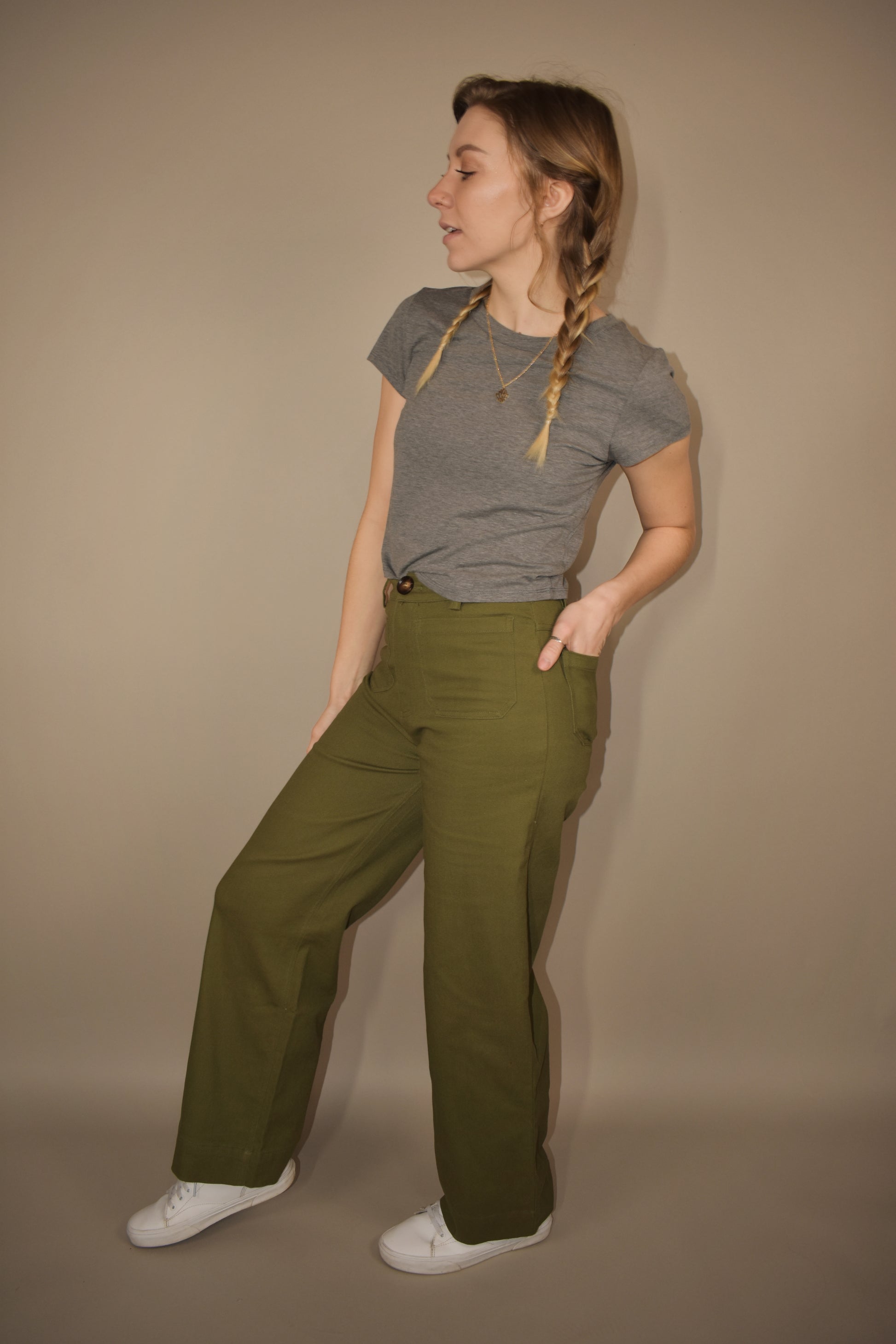 wide leg full length stretchy olive denim pants with brown front button. retro patch pockets on front and has back pockets too. no holes. high waisted.