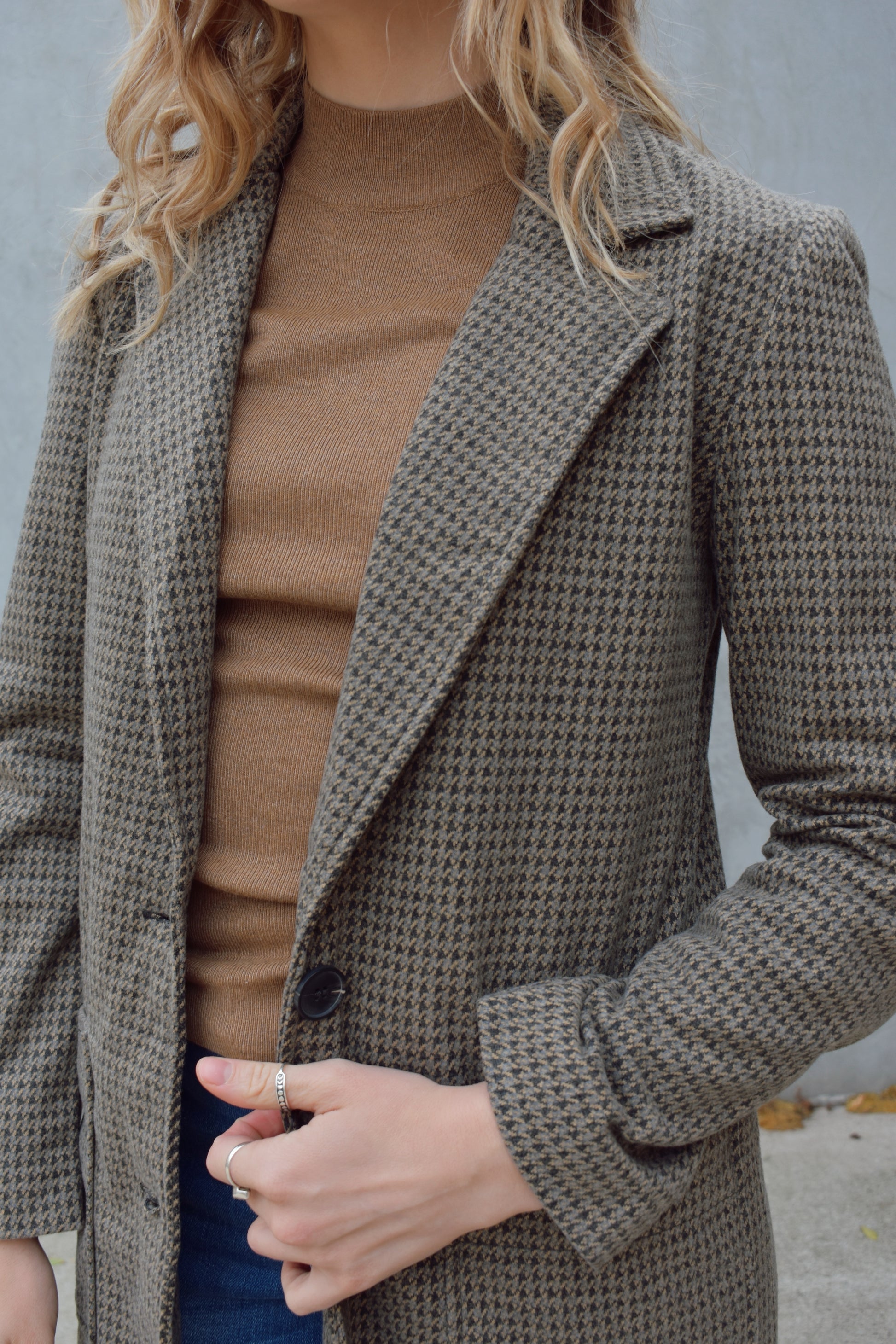 Houndstooth longline blazer, structured and fitted,  long sleeves, a notched collar, double button closure. patch pockets on front. hits above the knee.