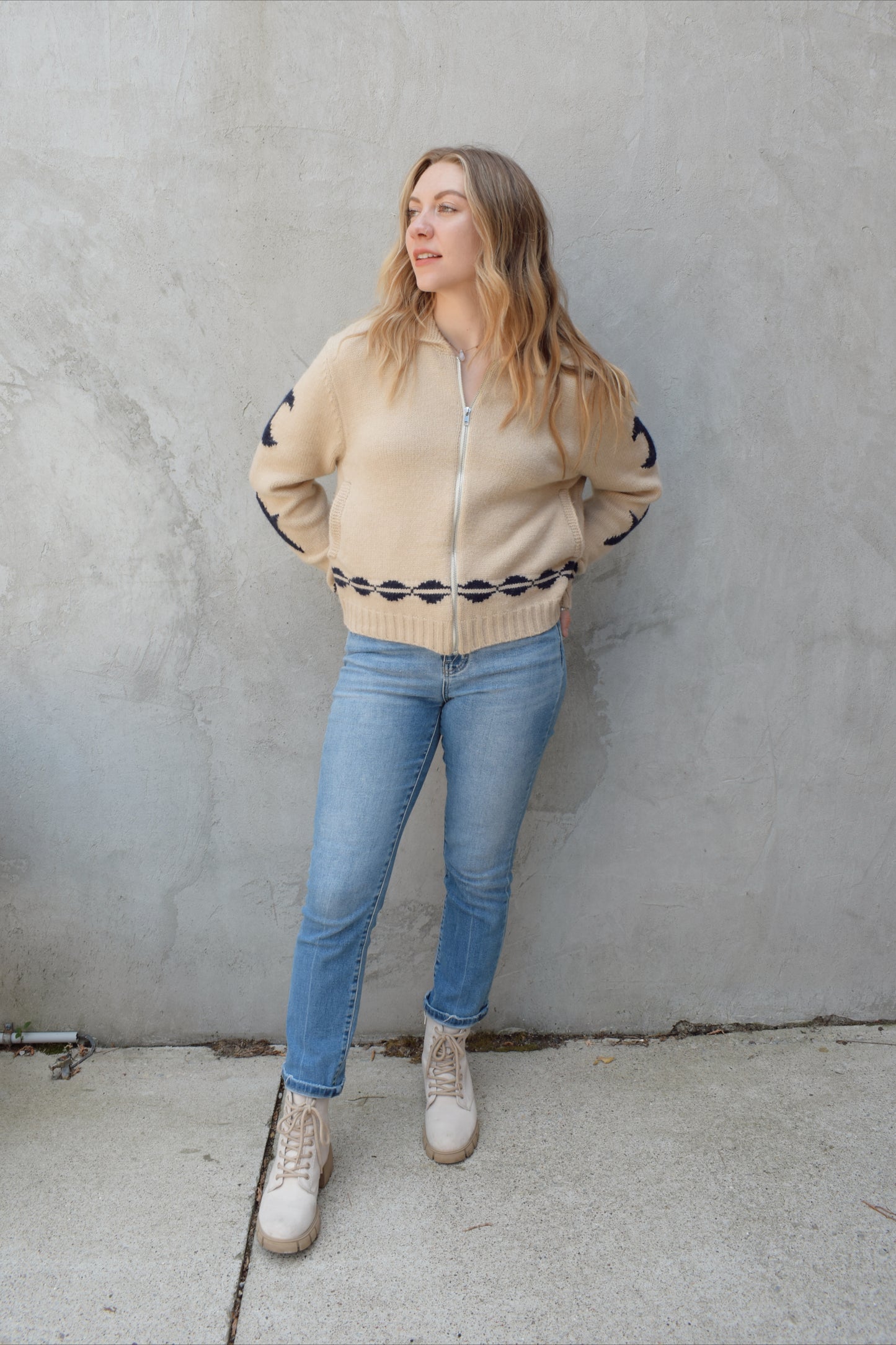 cream zip up sweater jacket with dark blue moon and stars on sleeves and trim design, collared neckline, ribbed hem and cuffs, side pockets, drop shoulders, relaxed fit