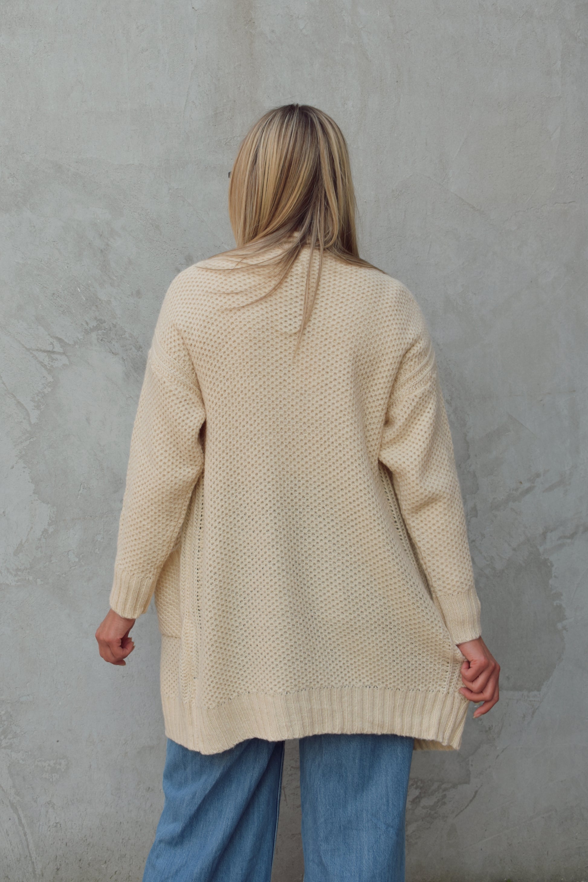 cream cardigan with front patch pockets, hangs straight , ribbed trim and hits mid thigh