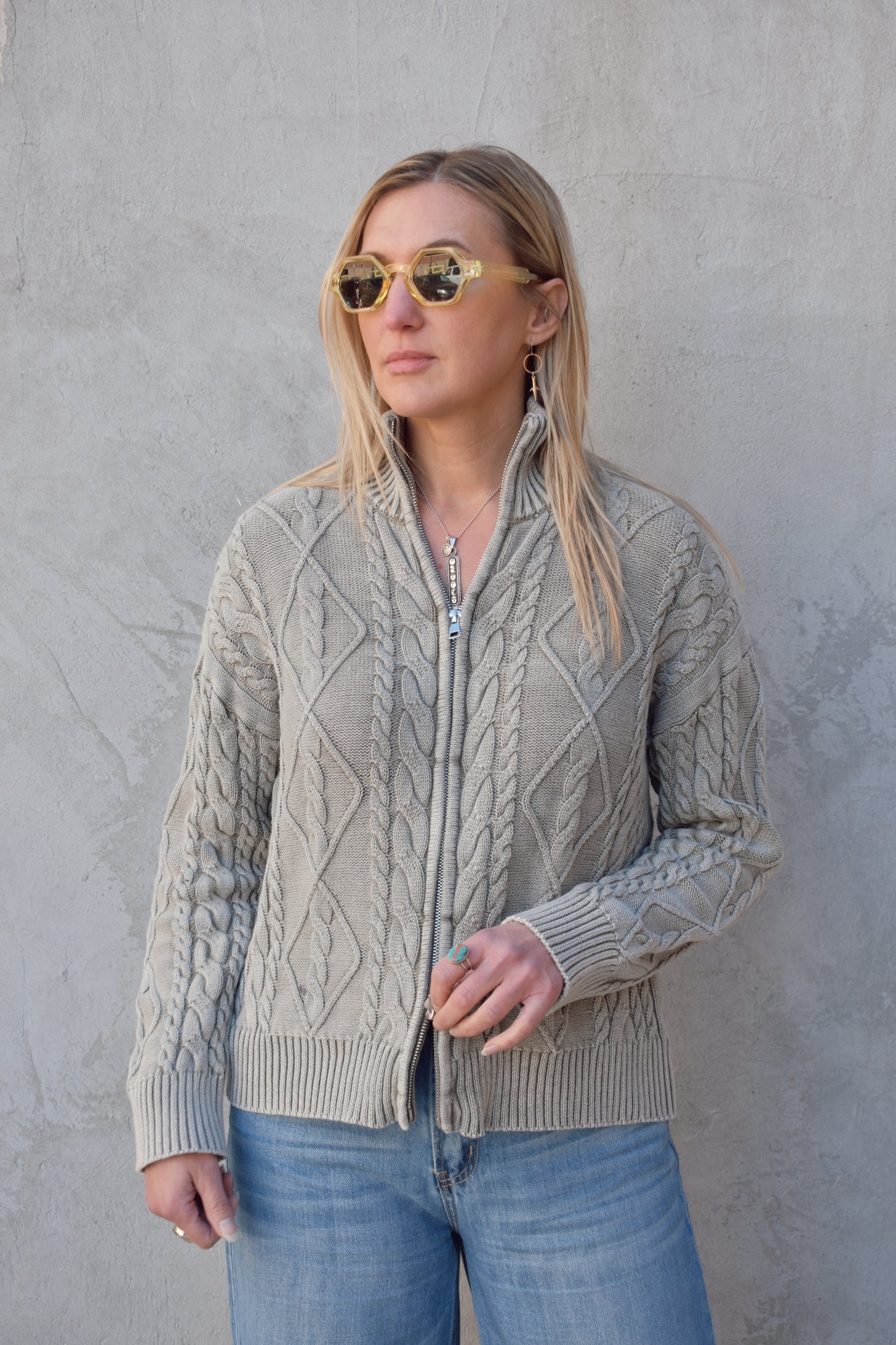 light gray twisted cable high neck sweater with front zip enclosure and it zips from both ways. ribbed cuffs, neck, and hem. drop shoulders.