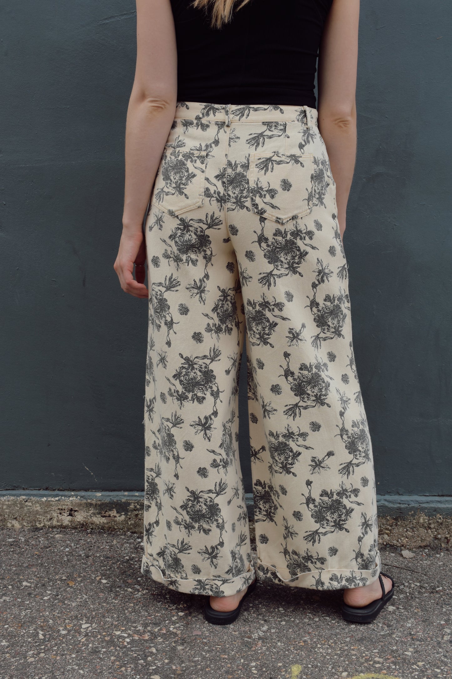 cream wide leg trousers with slate blue floral pattern, zip and button enclosure, front and back pockets, has beltloops, cuffed hem, high rise, statement pants, 100% cotton