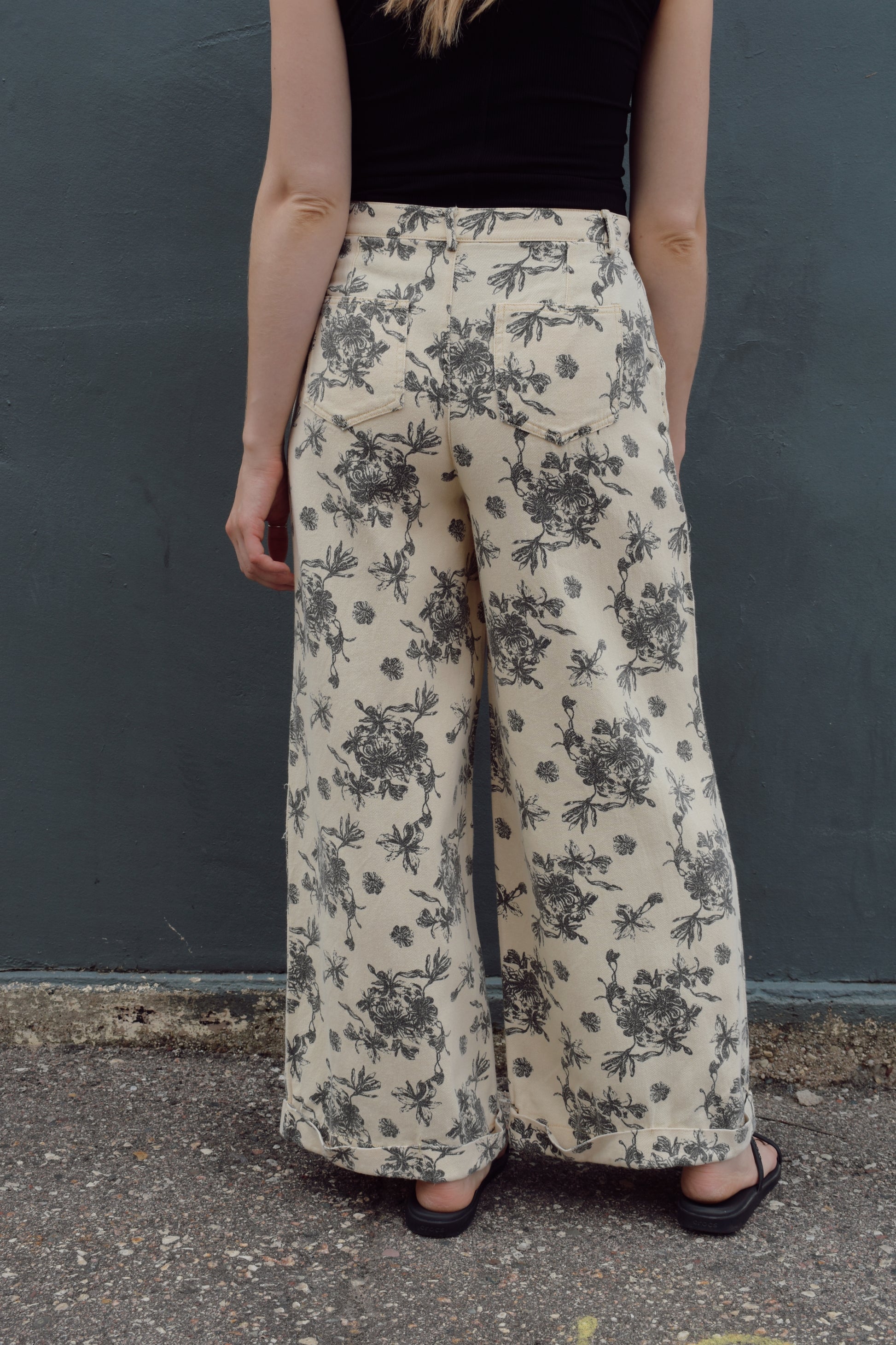 cream wide leg trousers with slate blue floral pattern, zip and button enclosure, front and back pockets, has beltloops, cuffed hem, high rise, statement pants, 100% cotton