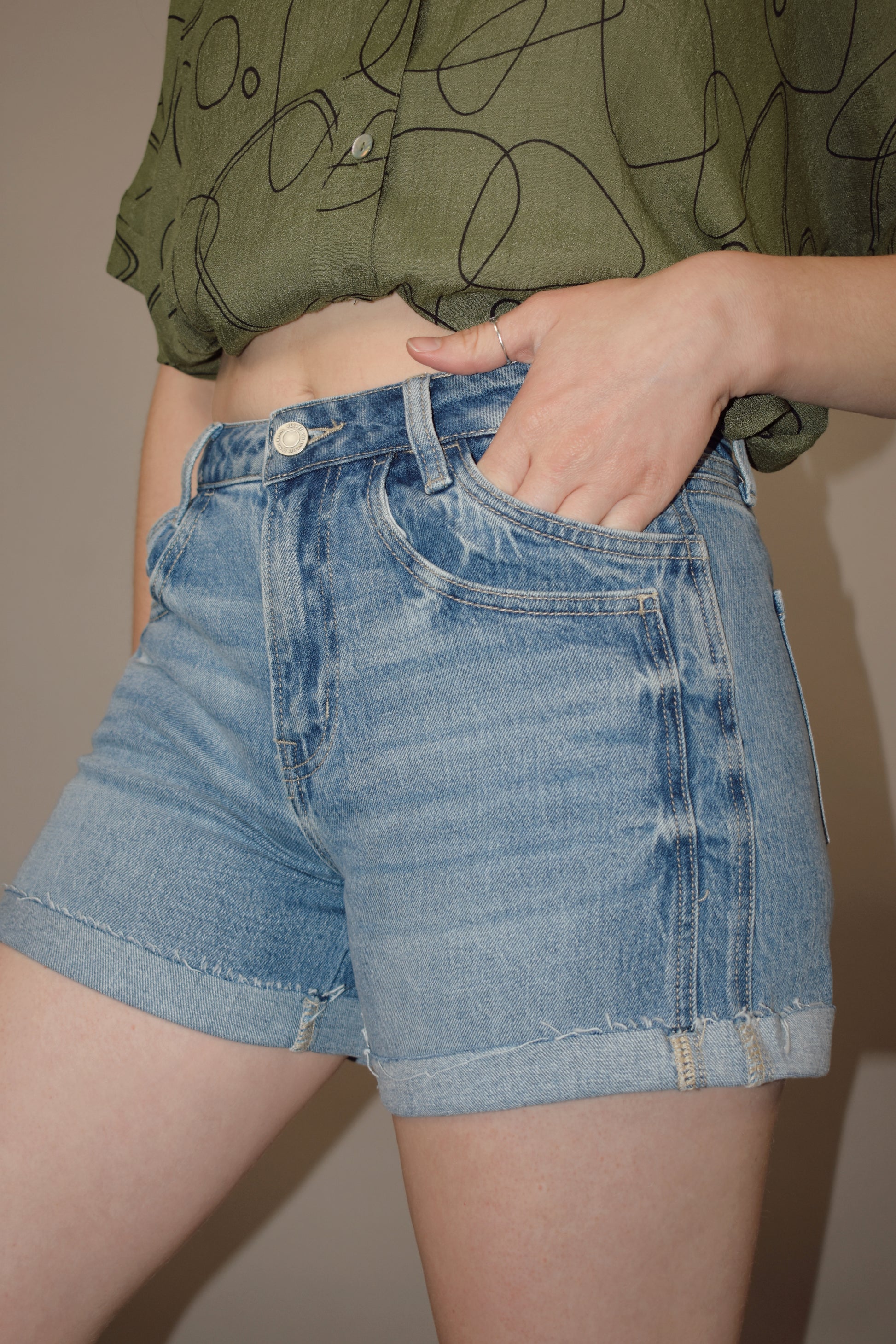 light wash cuffed denim shorts with a double pocket and seam detail, no holes, has a zip and button enclosure
