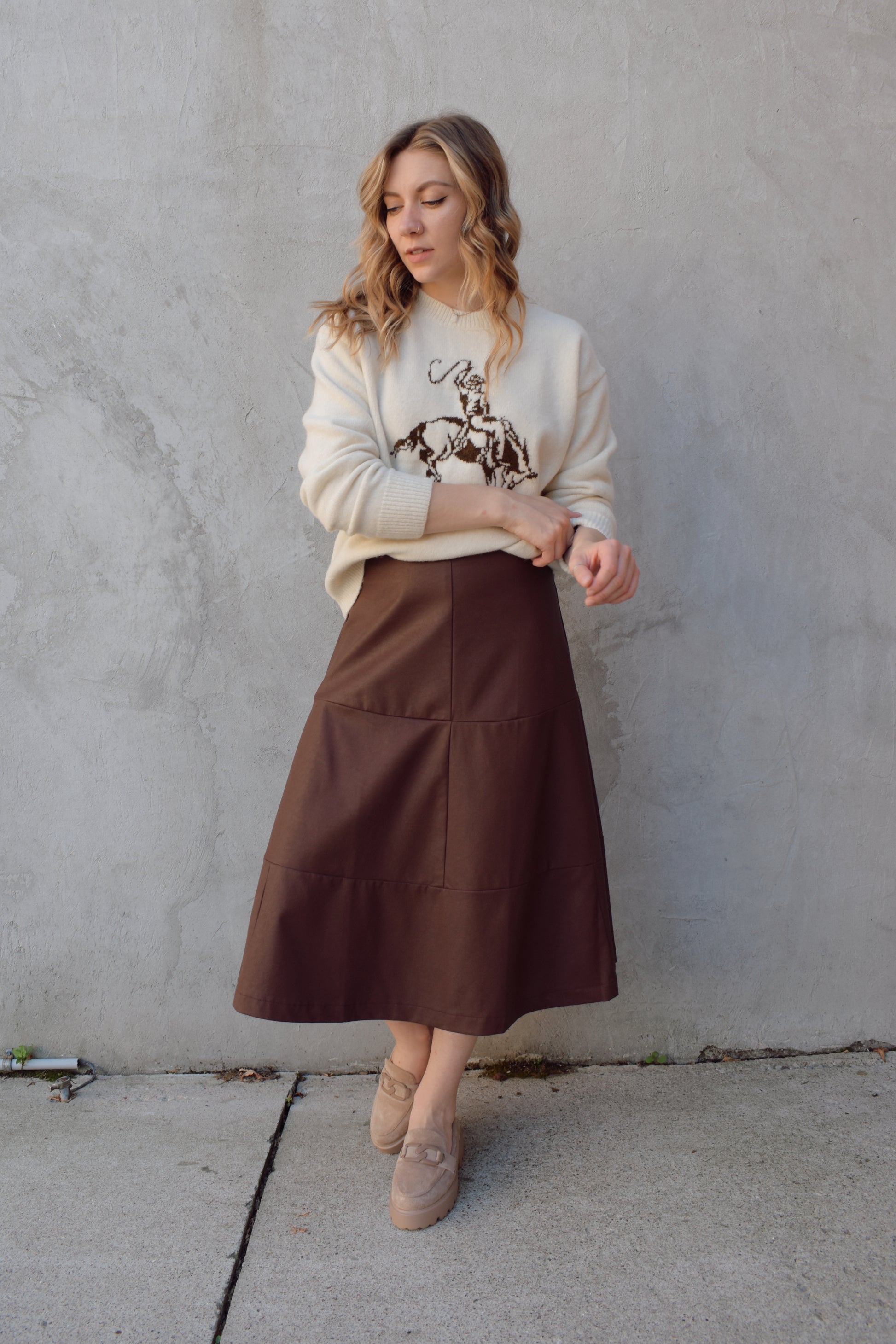 cream colored crew neck sweater relaxed fit full length with cowboy design in brown on front ribbed cuffs hem and neckline