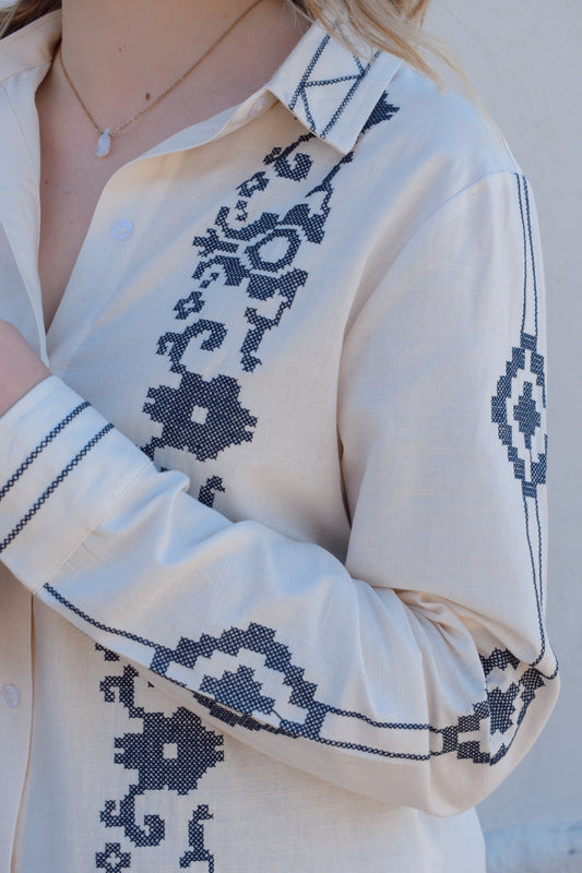 ivory button down full length with denim blue embroidery details along front, down sleeves, collar and cuffs. button cuffs, straight relaxed fit