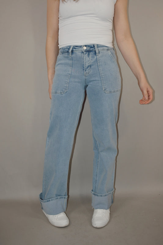 wide leg cuffed light wash stretch denim jeans with deep front patch style pockets and has a side carpenter pocket, no holes, zip and button enclosure, high rise.