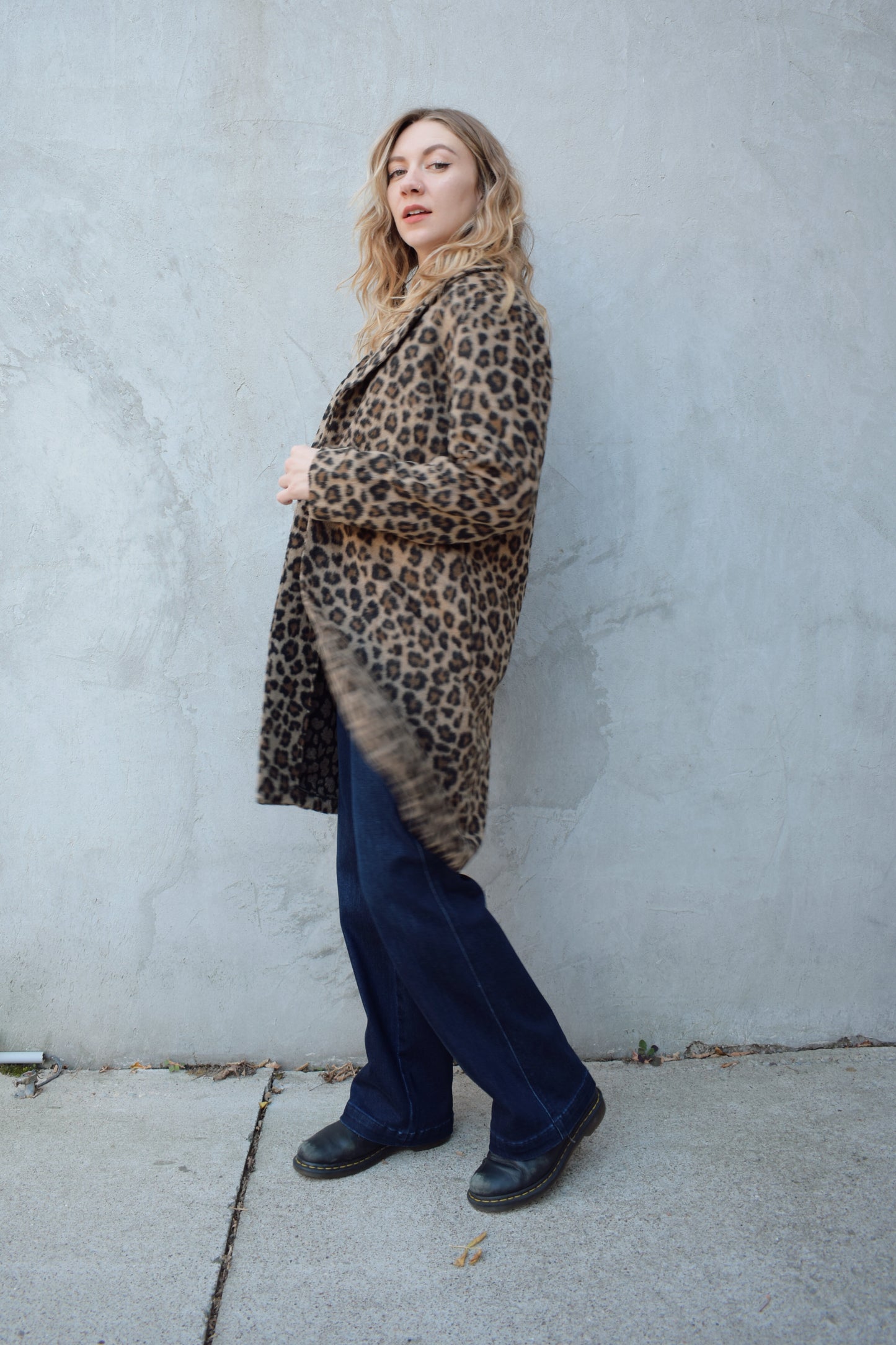 leopard print coat with collar and singular button enclosure has pockets hits just above the knee