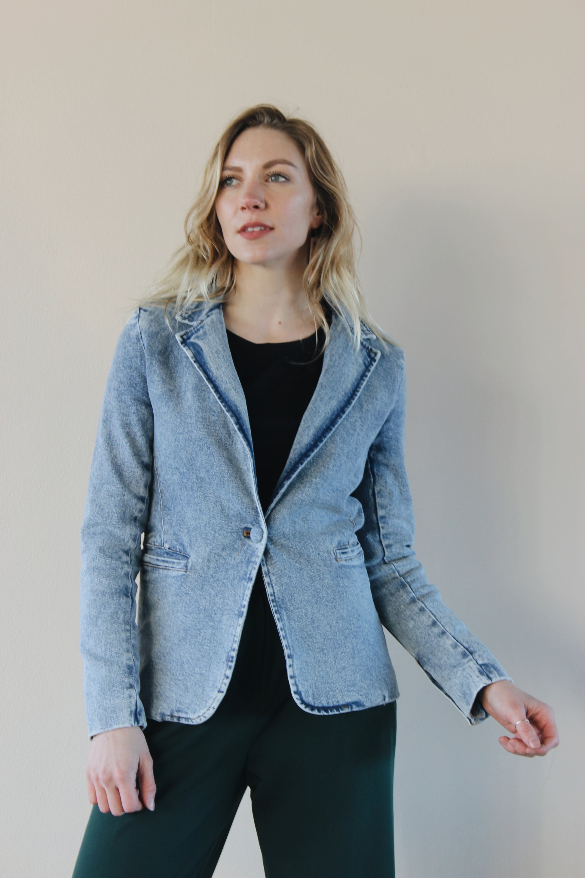 fitted light to medium wash blazer with one denim button enclosure and front pockets that open on the top. slit in back 