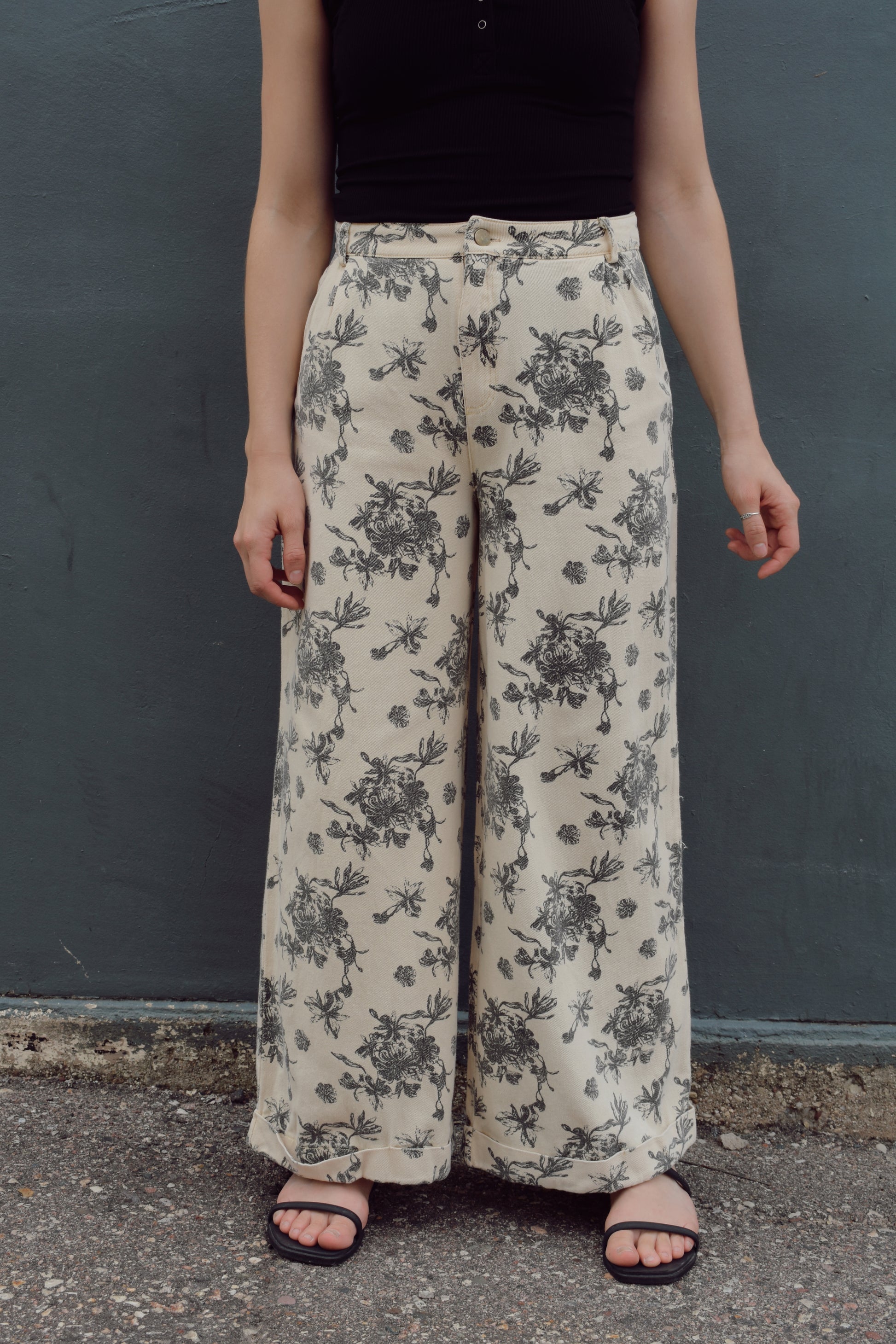 cream wide leg trousers with slate blue floral pattern, zip and button enclosure, front and back pockets, has beltloops, cuffed hem, high rise, statement pants, 100% cotton