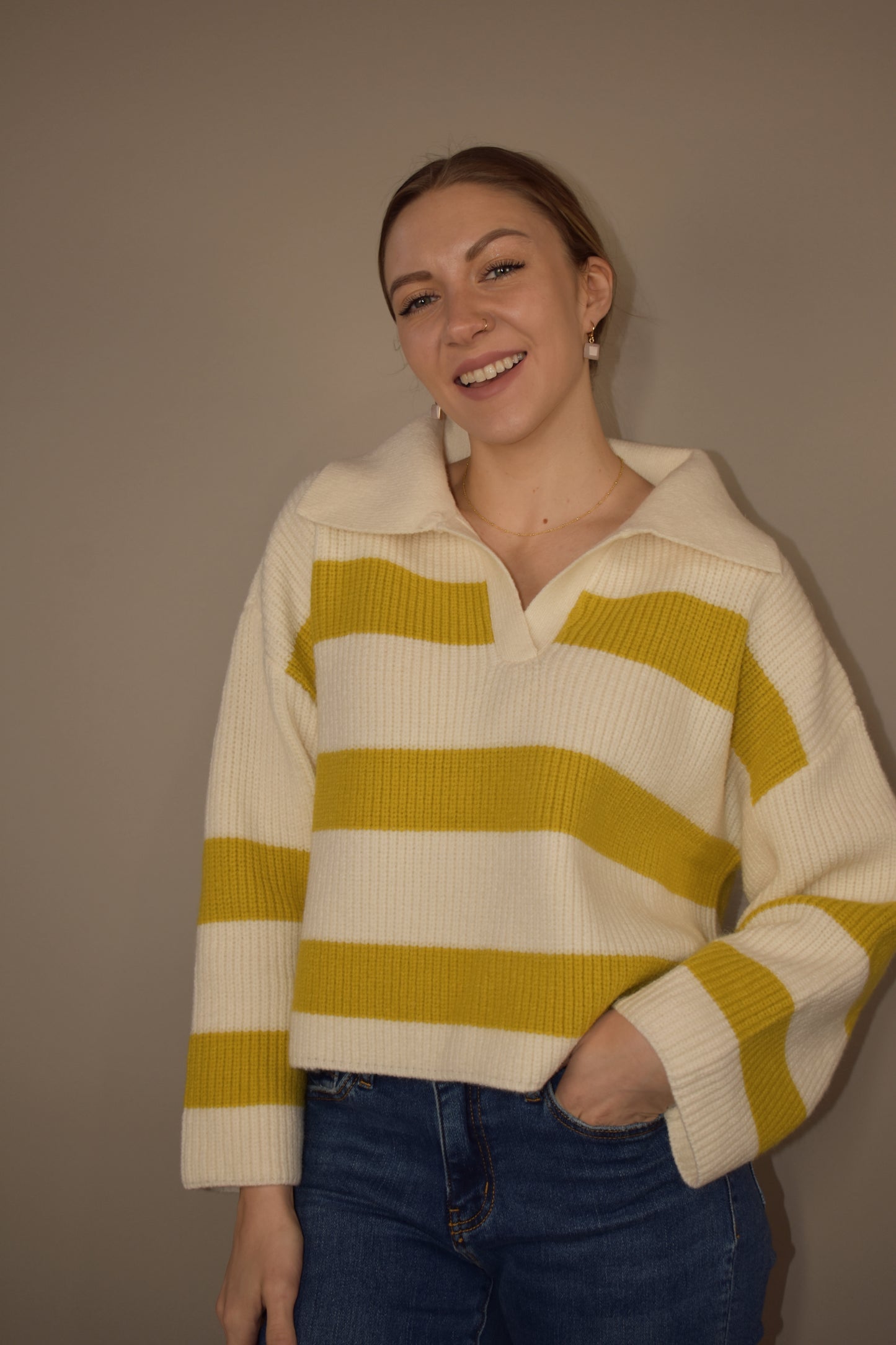 Loose fitting collared sweater with thick mustard colored stripes and a cream background and collar. Color is wide. Slight V neck. Waist length. 