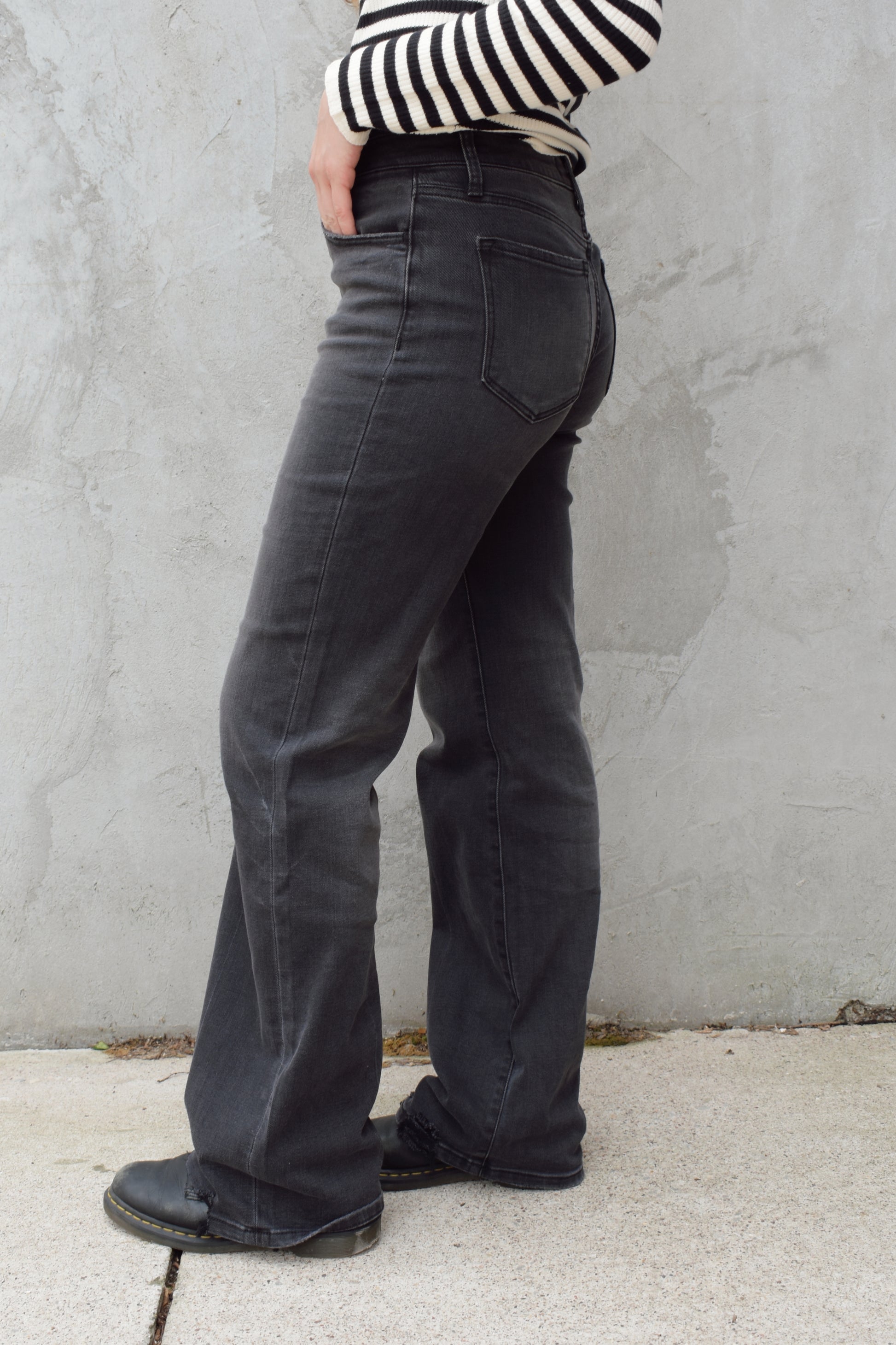 high rise washed black wide leg flare jeans full length stretch denim distressed hem but no holes zip and button enclosure has beltloops has front and back pockets 