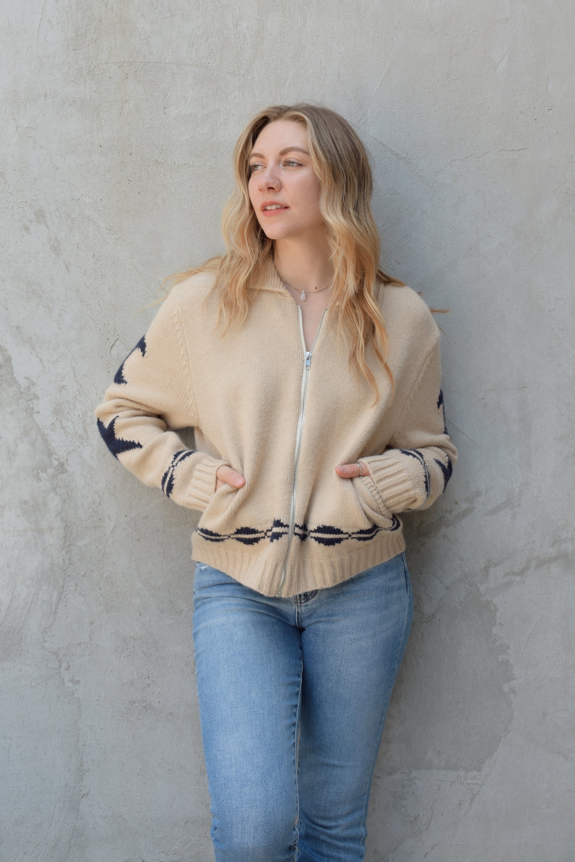 cream zip up sweater jacket with dark blue moon and stars on sleeves and trim design, collared neckline, ribbed hem and cuffs, side pockets, drop shoulders, relaxed fit