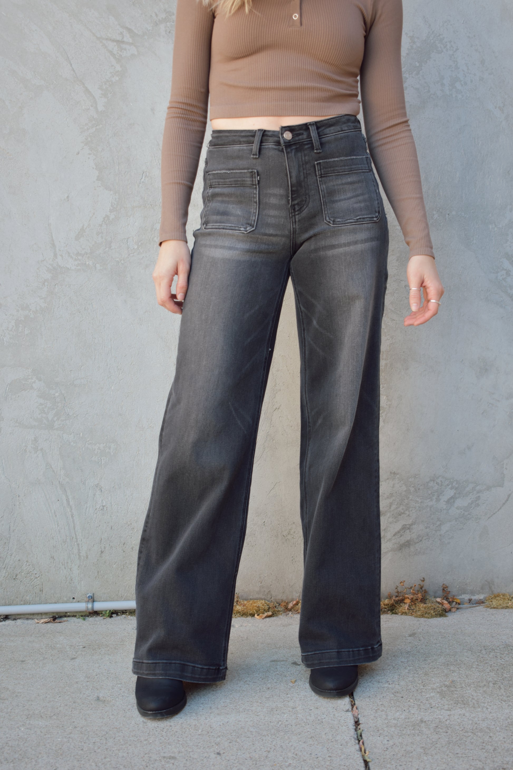 wide leg trouser style jeans with patch front pockets. washed out black color. no distressing. high rise and stretch denim.