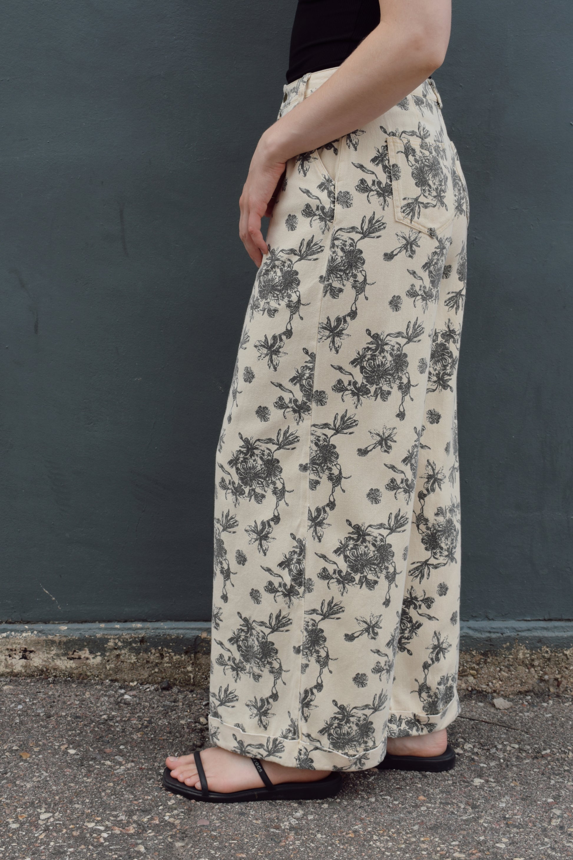 cream wide leg trousers with slate blue floral pattern, zip and button enclosure, front and back pockets, has beltloops, cuffed hem, high rise, statement pants, 100% cotton