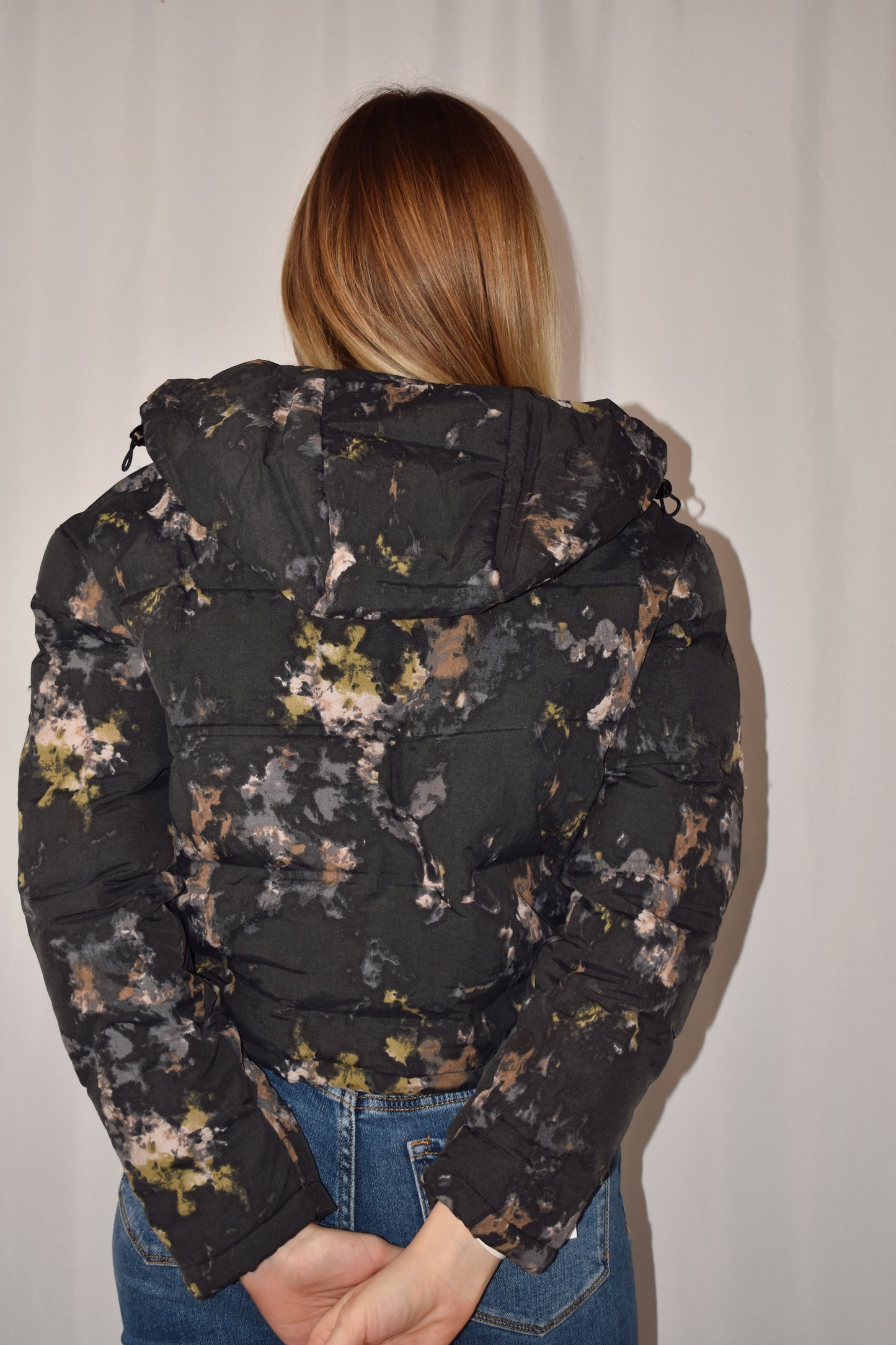 Watercolor puffer jacket, cropped length with drawstring at hem, hood, zip and snap front enclosure, side pockets. 