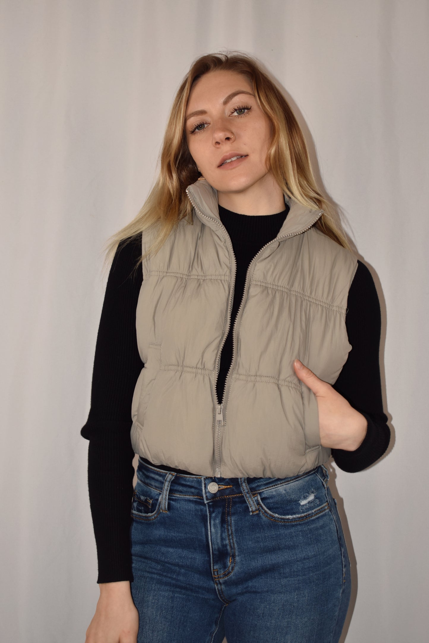 Cropped puffer vest with tight synching and side pockets. Zipper front enclosure. 