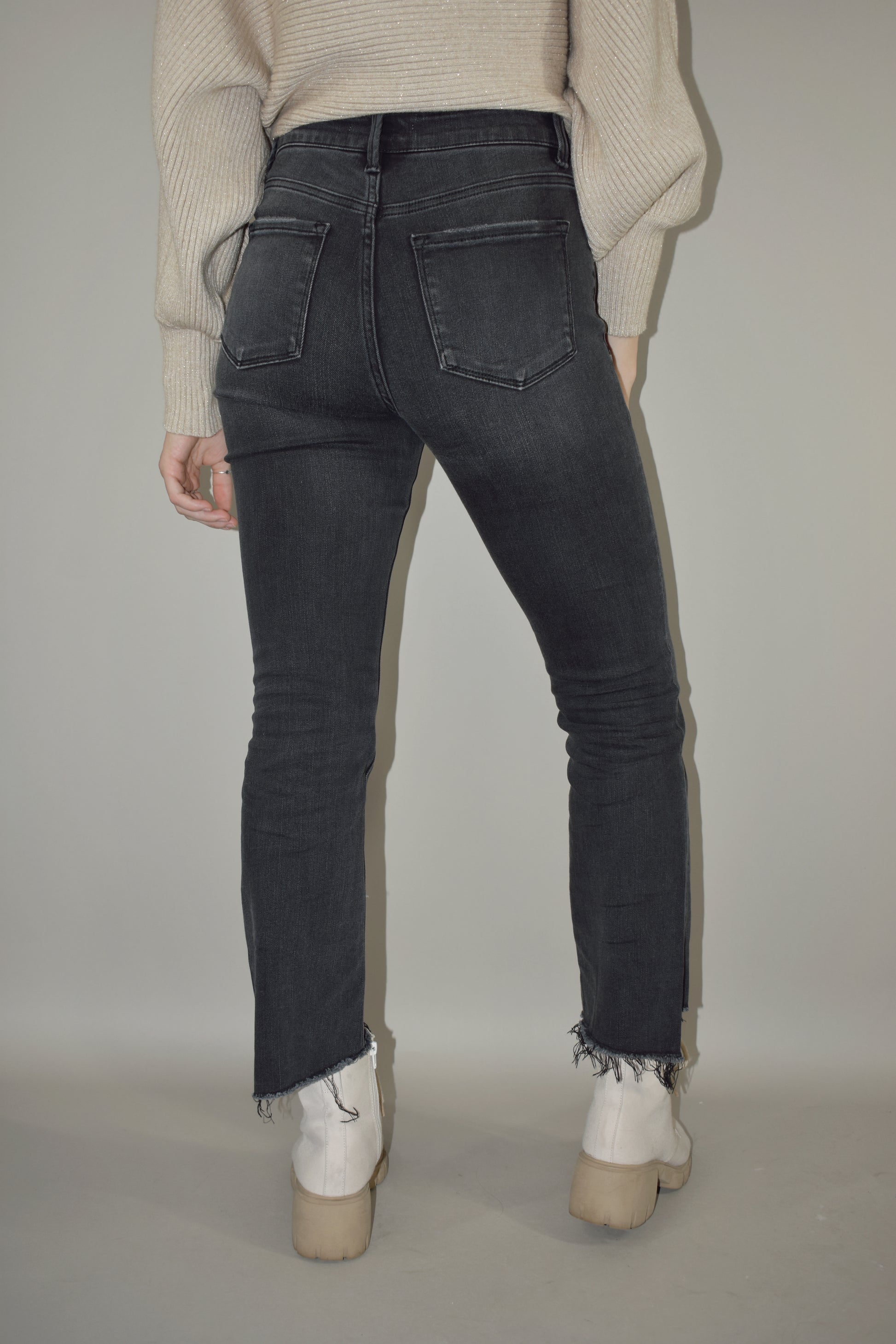 high waisted stretch washed black denim jeans cropped with uneven raw hem and has a straight fit with no holes