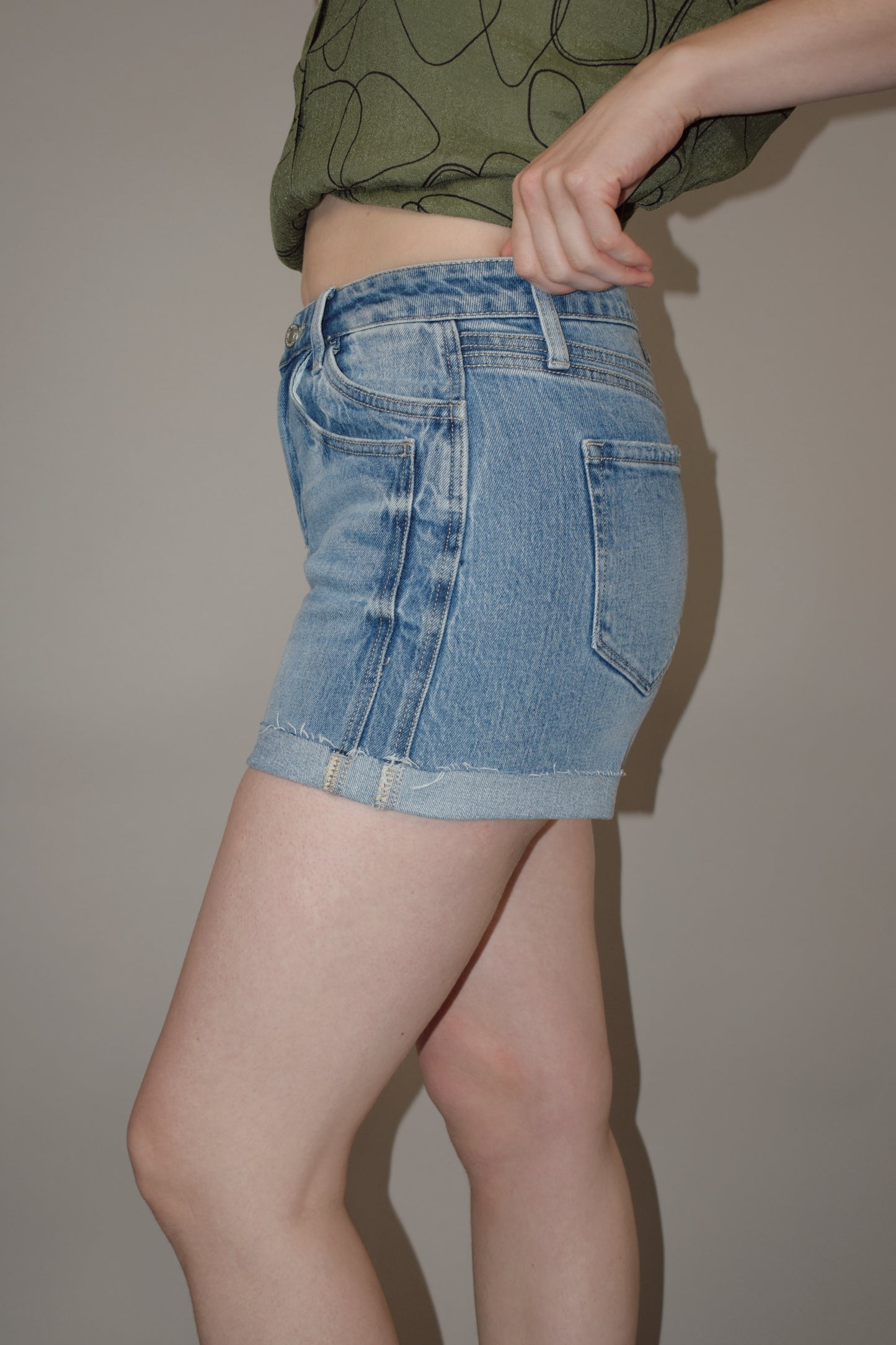 light wash cuffed denim shorts with a double pocket and seam detail, no holes, has a zip and button enclosure