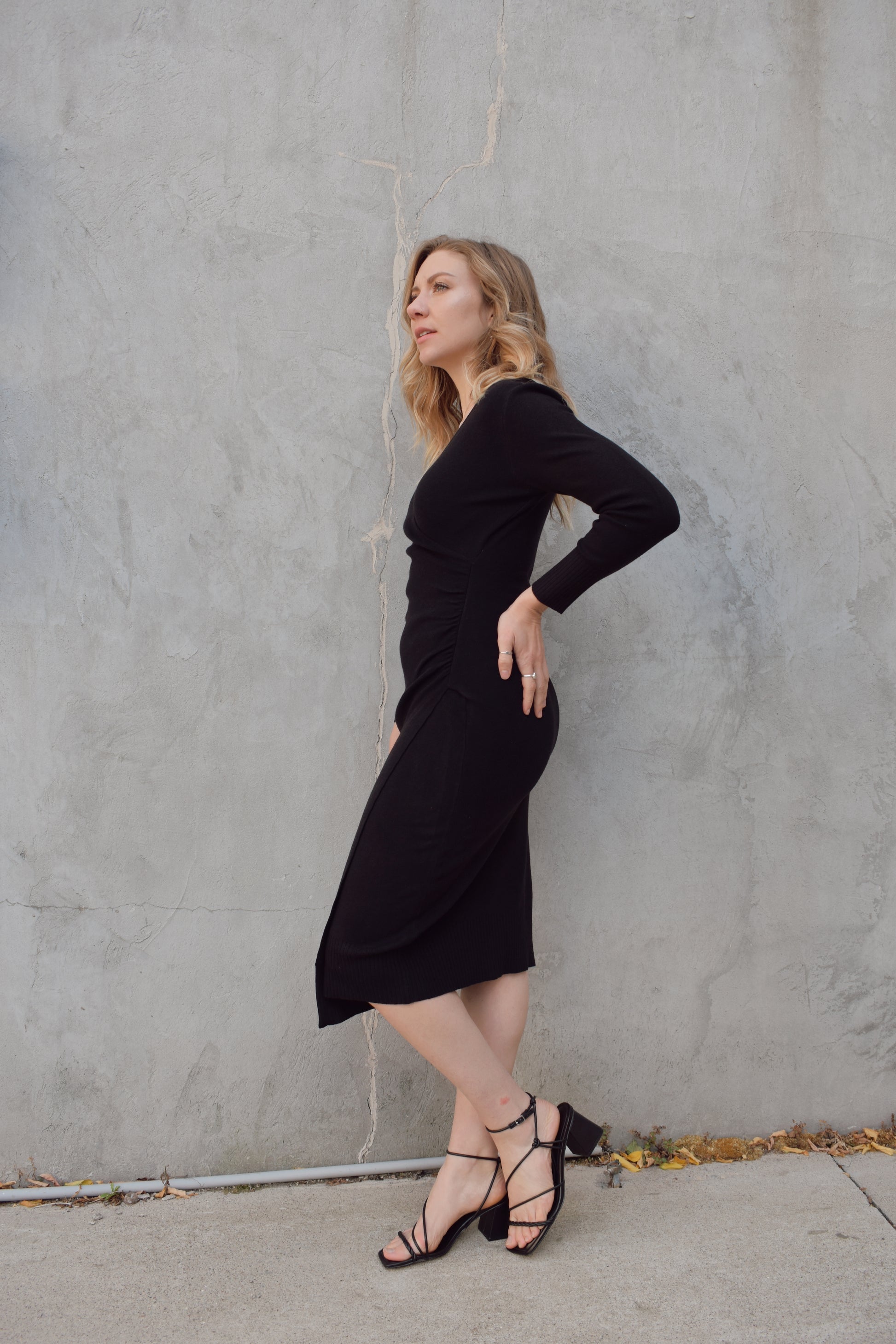 long sleeve black midi wrap dress with v neck and ruching detail on side of bodice by seam, surplice hem, thick material, fitted.