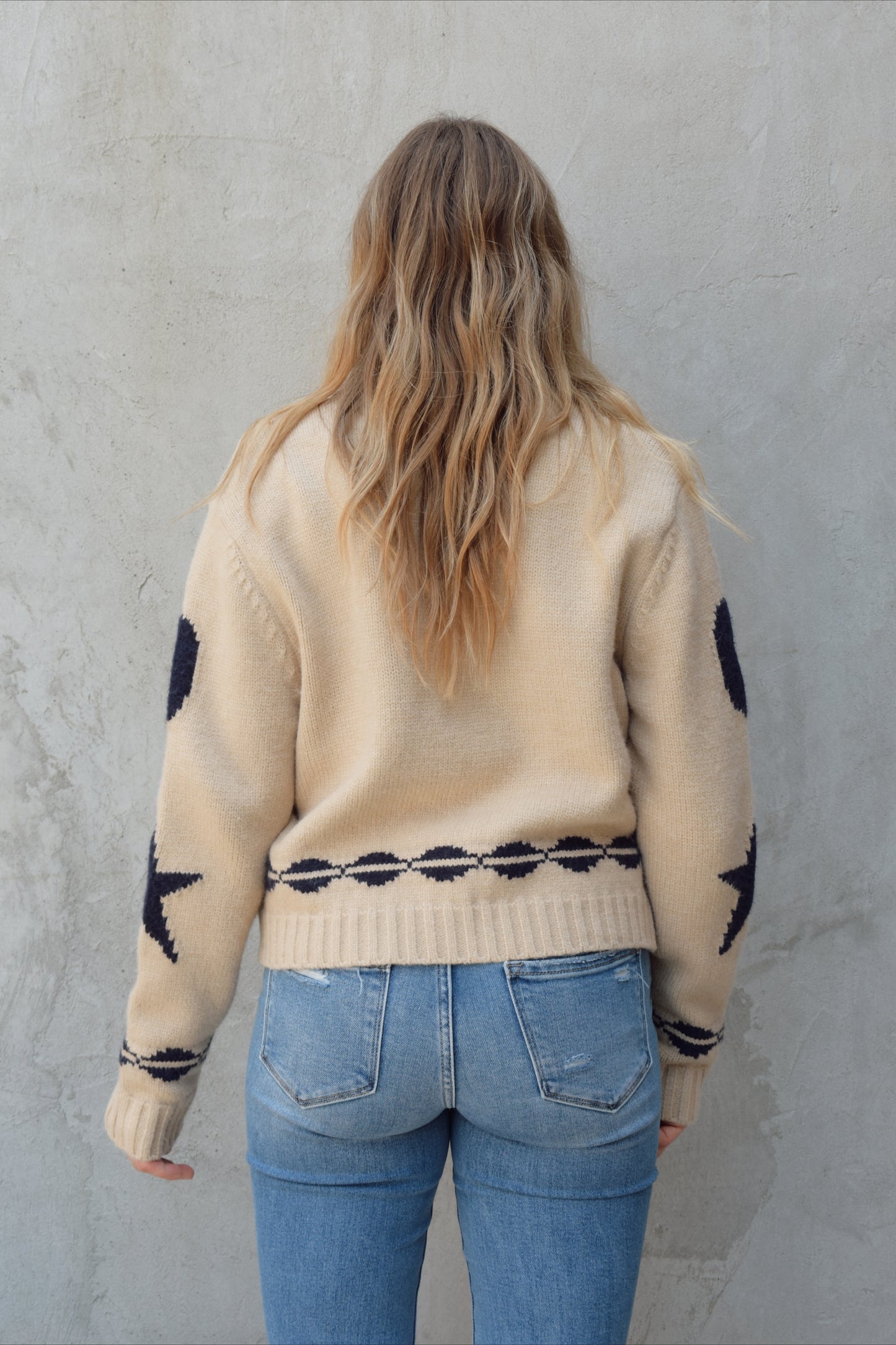 cream zip up sweater jacket with dark blue moon and stars on sleeves and trim design, collared neckline, ribbed hem and cuffs, side pockets, drop shoulders, relaxed fit