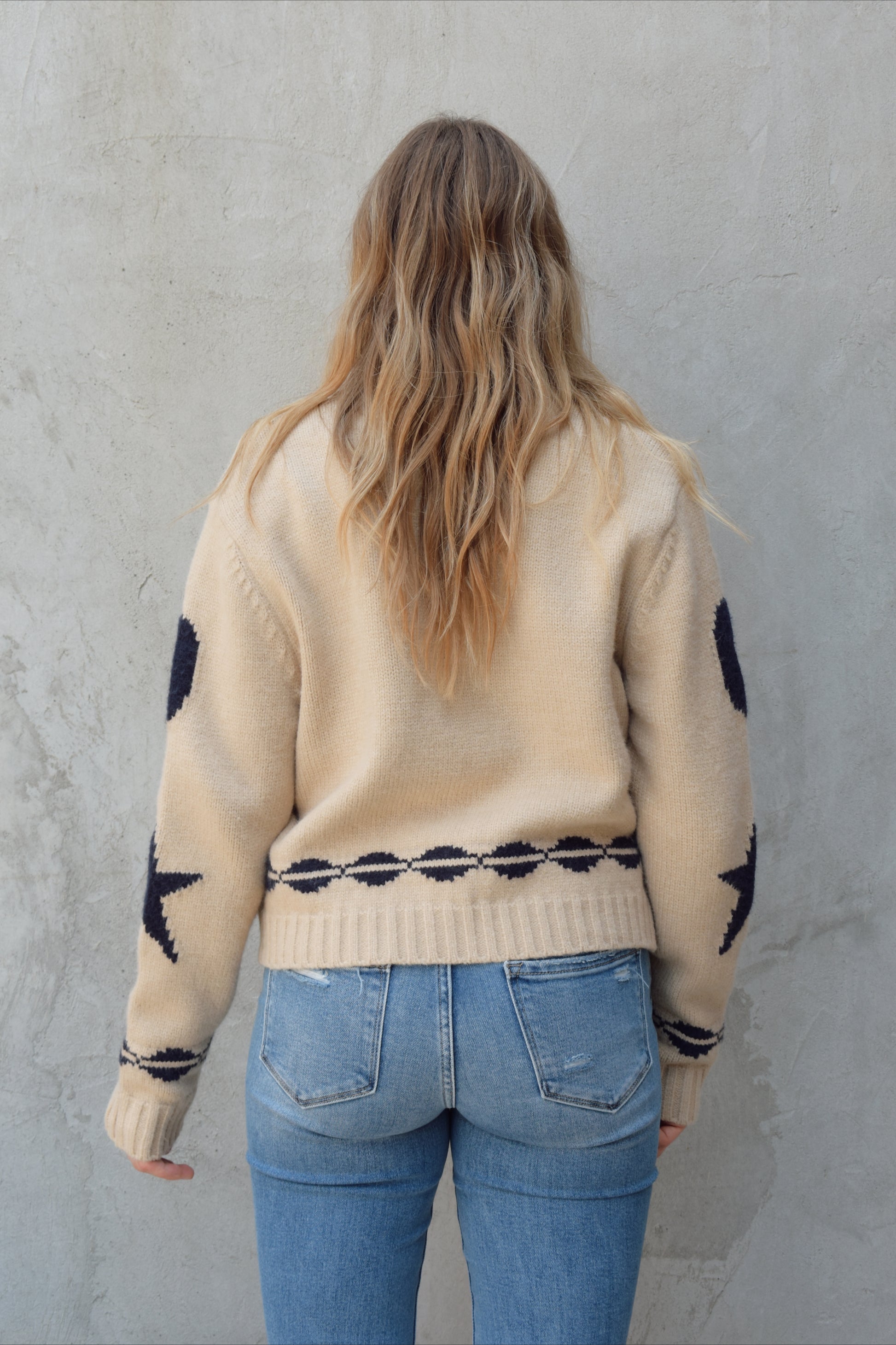 cream zip up sweater jacket with dark blue moon and stars on sleeves and trim design, collared neckline, ribbed hem and cuffs, side pockets, drop shoulders, relaxed fit