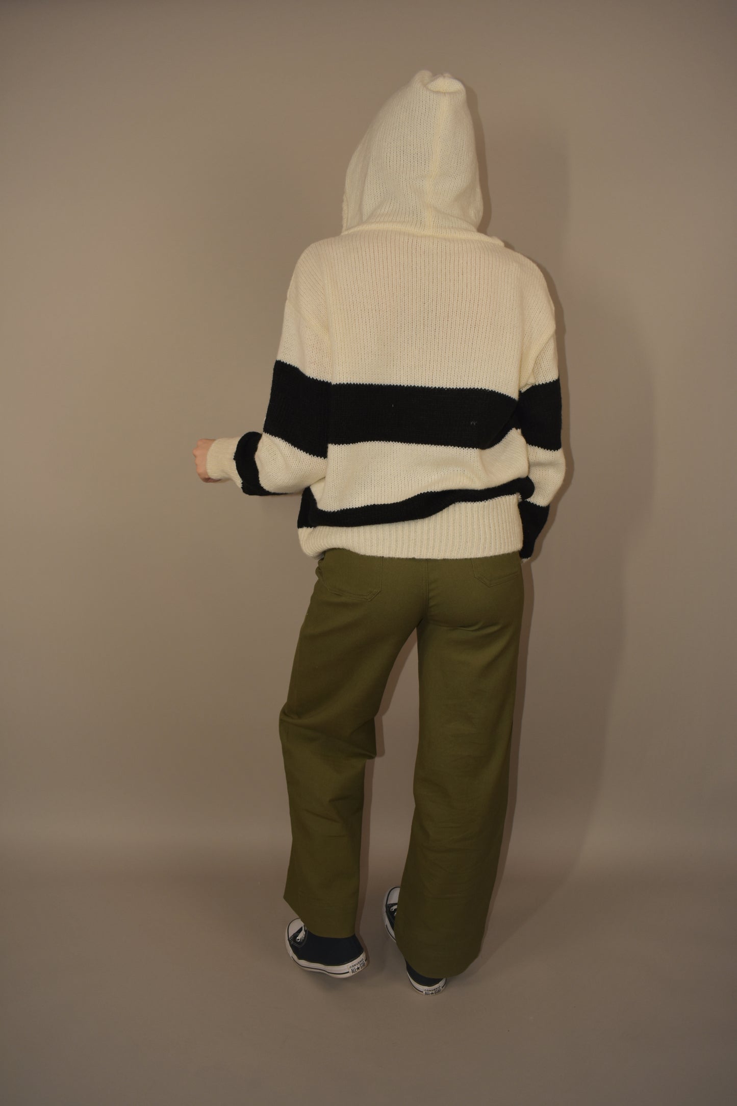 oversized knitted hoodie with two black stripes across the body and goes onto the arms