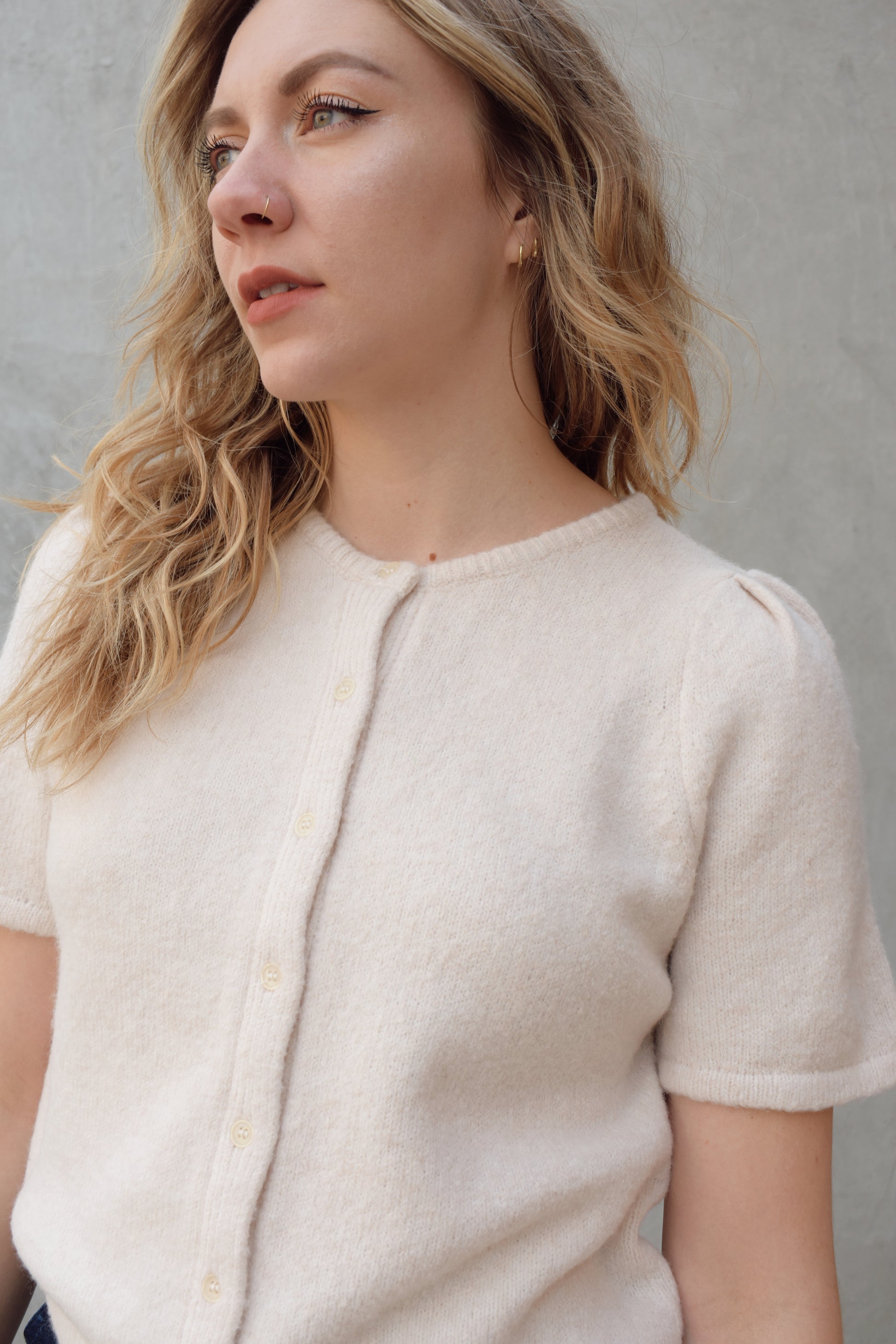 short sleeve cardigan sweater with crew neckline and slight puff sleeves gathered at shoulder, ribbed hem, straight fit, hits at waistline