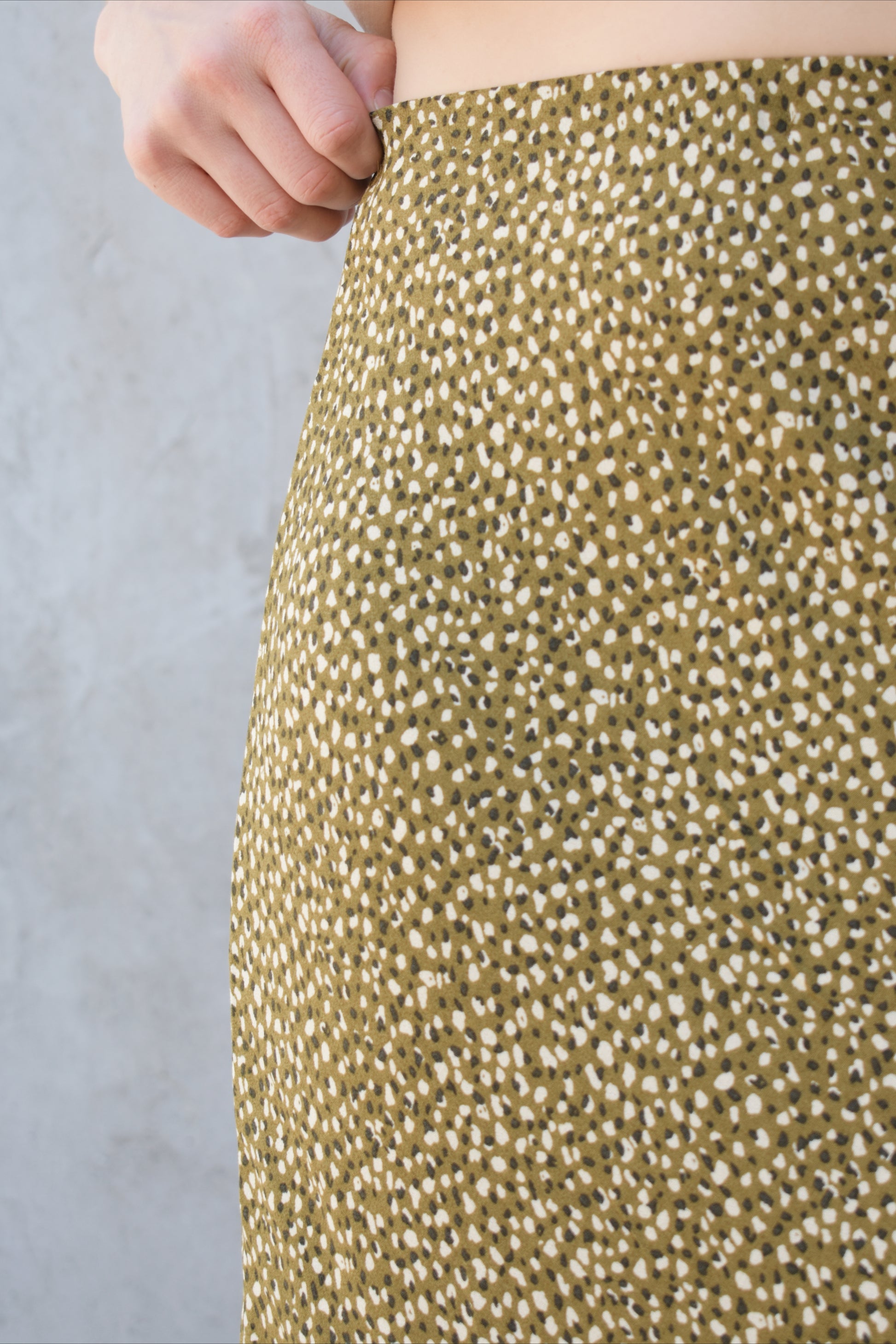 lightweight midi skirt with elastic waistband, no pockets, olive green background with black and cream dotted pattern