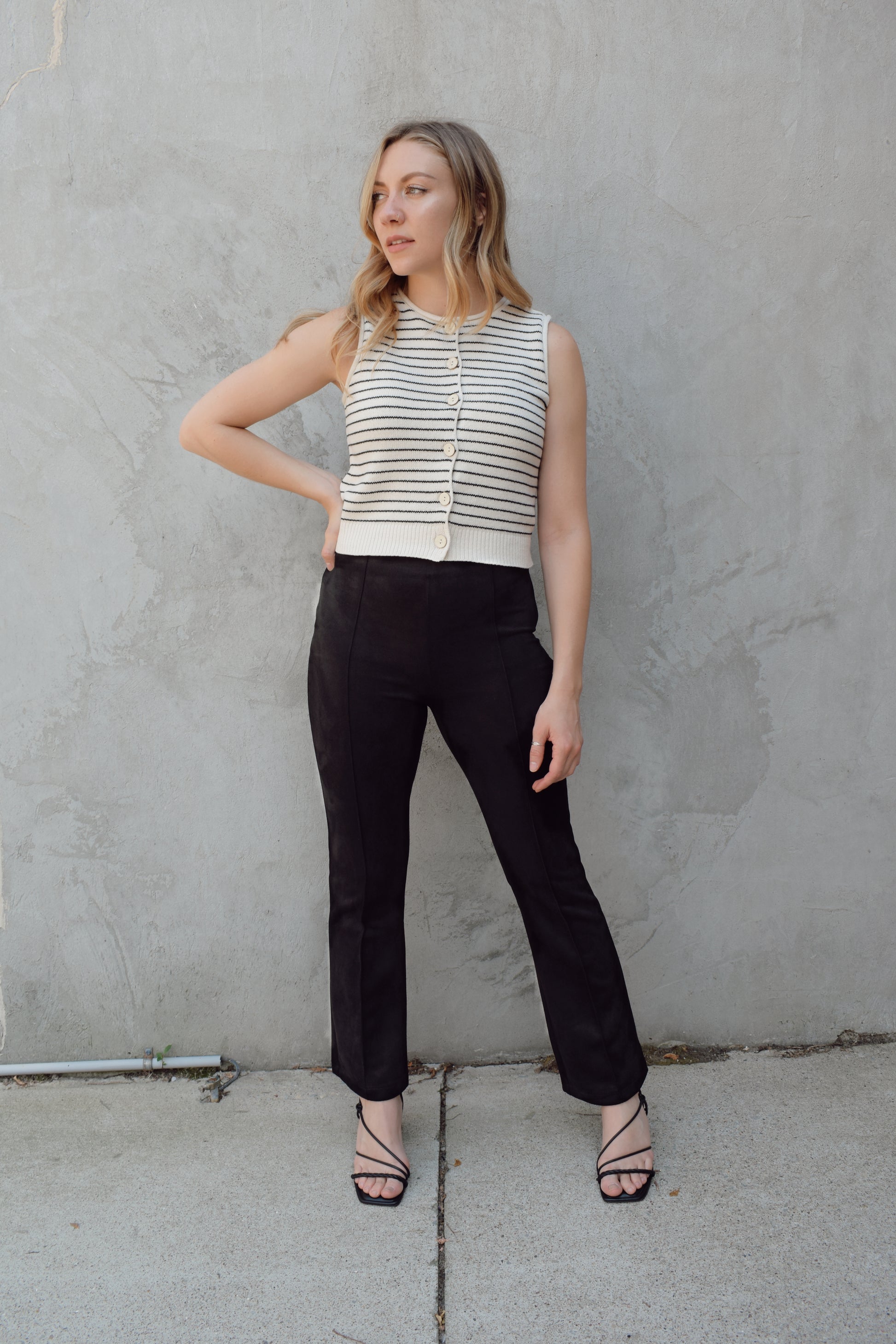 black faux suede pants with a slight cropped kick flare, raised seam detail along front of pant legs, zip side enclosure, high waisted