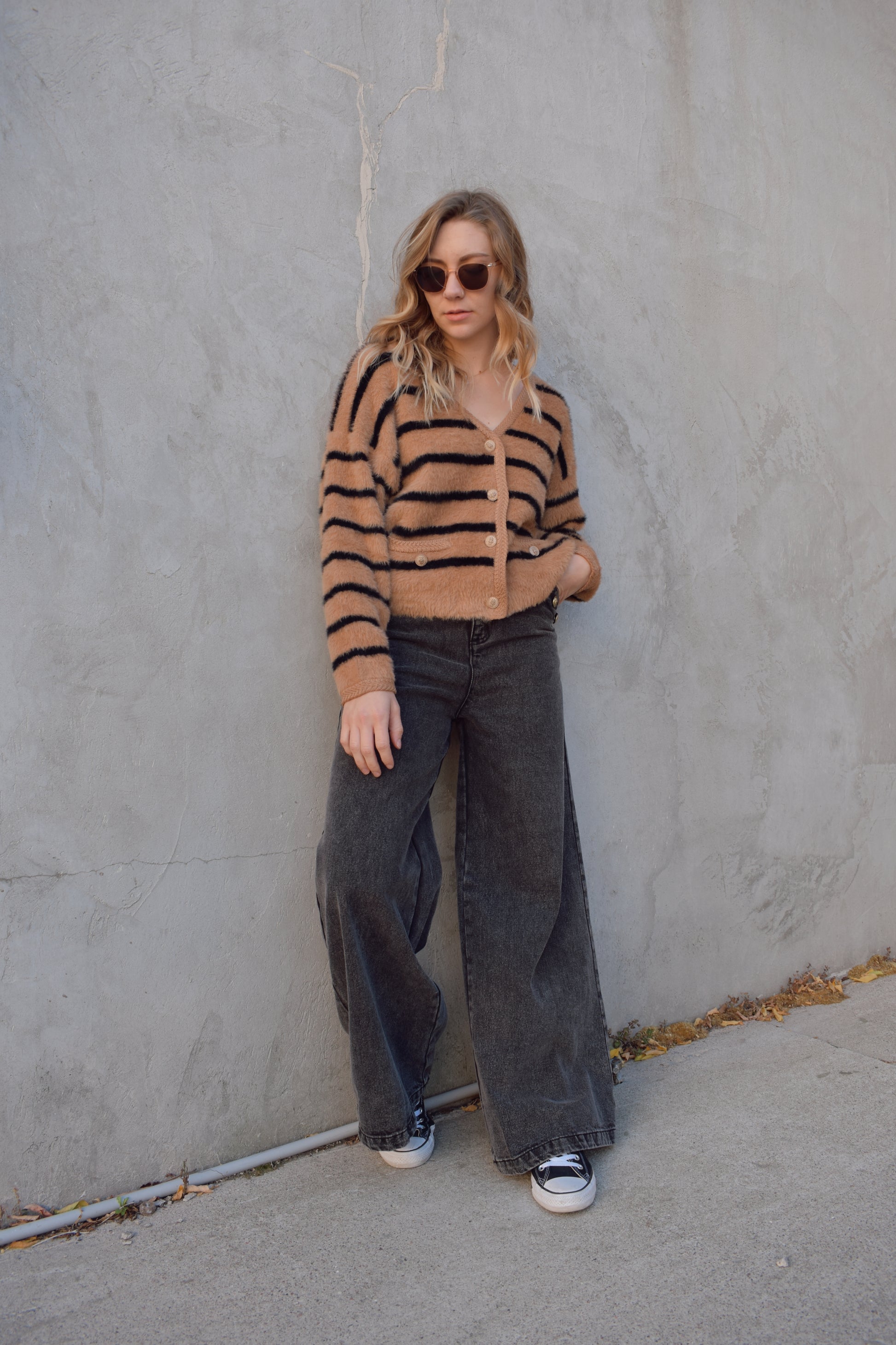 light brown mohair v neck button down cardigan with light brown sailor buttons and black horizontal stripes. two pockets on front that open at the top. outlined with a braided texture on neck line and down the front and on edge of pockets. drop shoulders, slightly cropped.