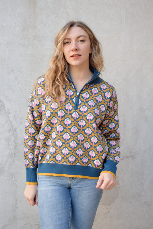 half zip relaxed fit statement pattern pullover with blue and yellow band at ham and cuff and just blue on collar. pattern is yellow, white, and pink on a blue background