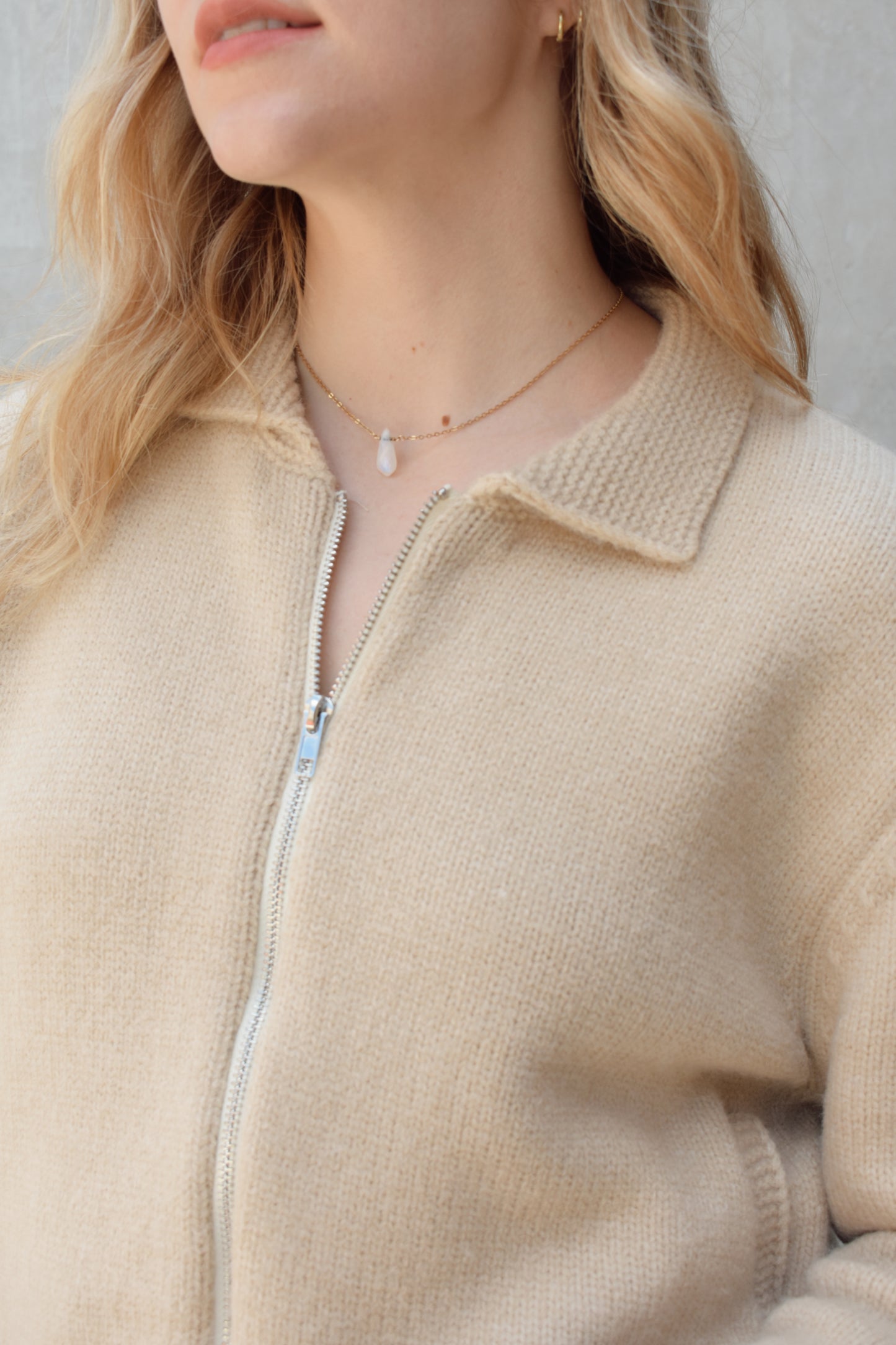 cream zip up sweater jacket with dark blue moon and stars on sleeves and trim design, collared neckline, ribbed hem and cuffs, side pockets, drop shoulders, relaxed fit