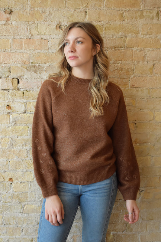 brown crew neck sweater with 3d floral design on sleeves full length ribbed collar cuffs and hem relaxed fit
