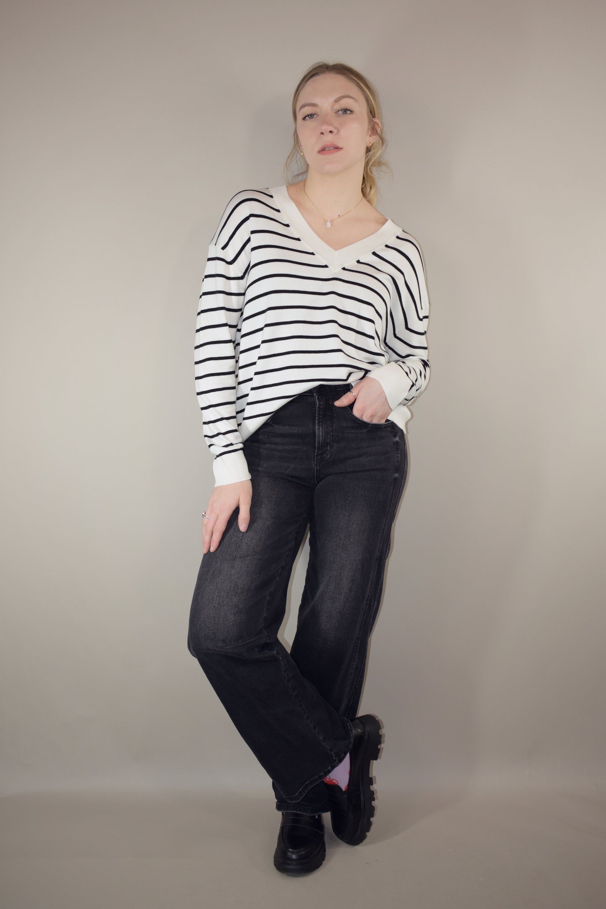 long sleeve full length v neck light weight sweater with horizontal black stripes, solid white hem, loose fit, drop shoulders, super soft.