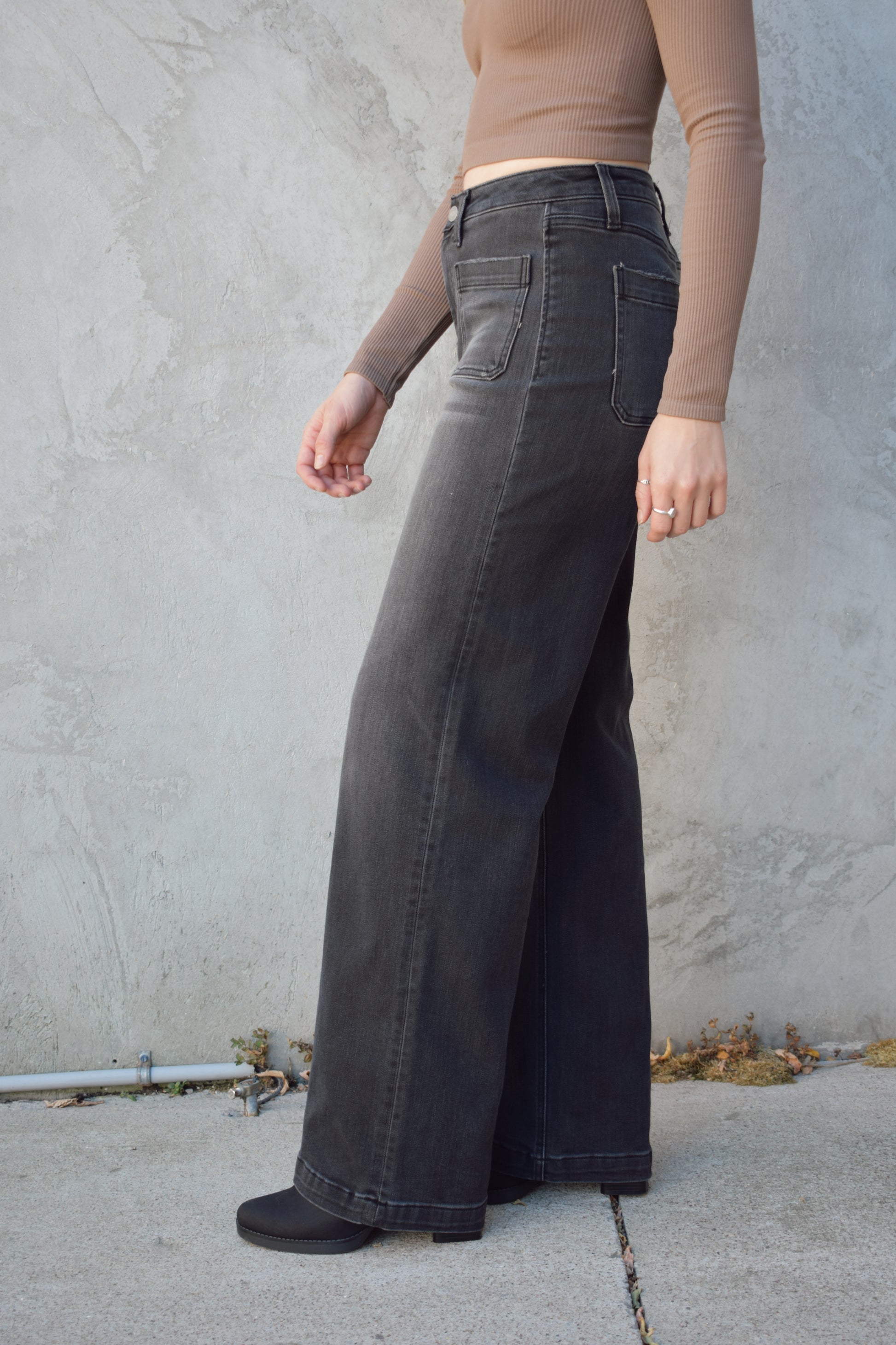 wide leg trouser style jeans with patch front pockets. washed out black color. no distressing. high rise and stretch denim.