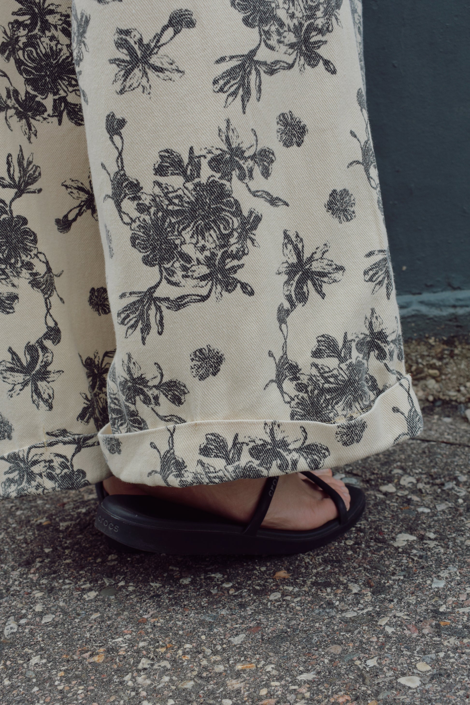 cream wide leg trousers with slate blue floral pattern, zip and button enclosure, front and back pockets, has beltloops, cuffed hem, high rise, statement pants, 100% cotton