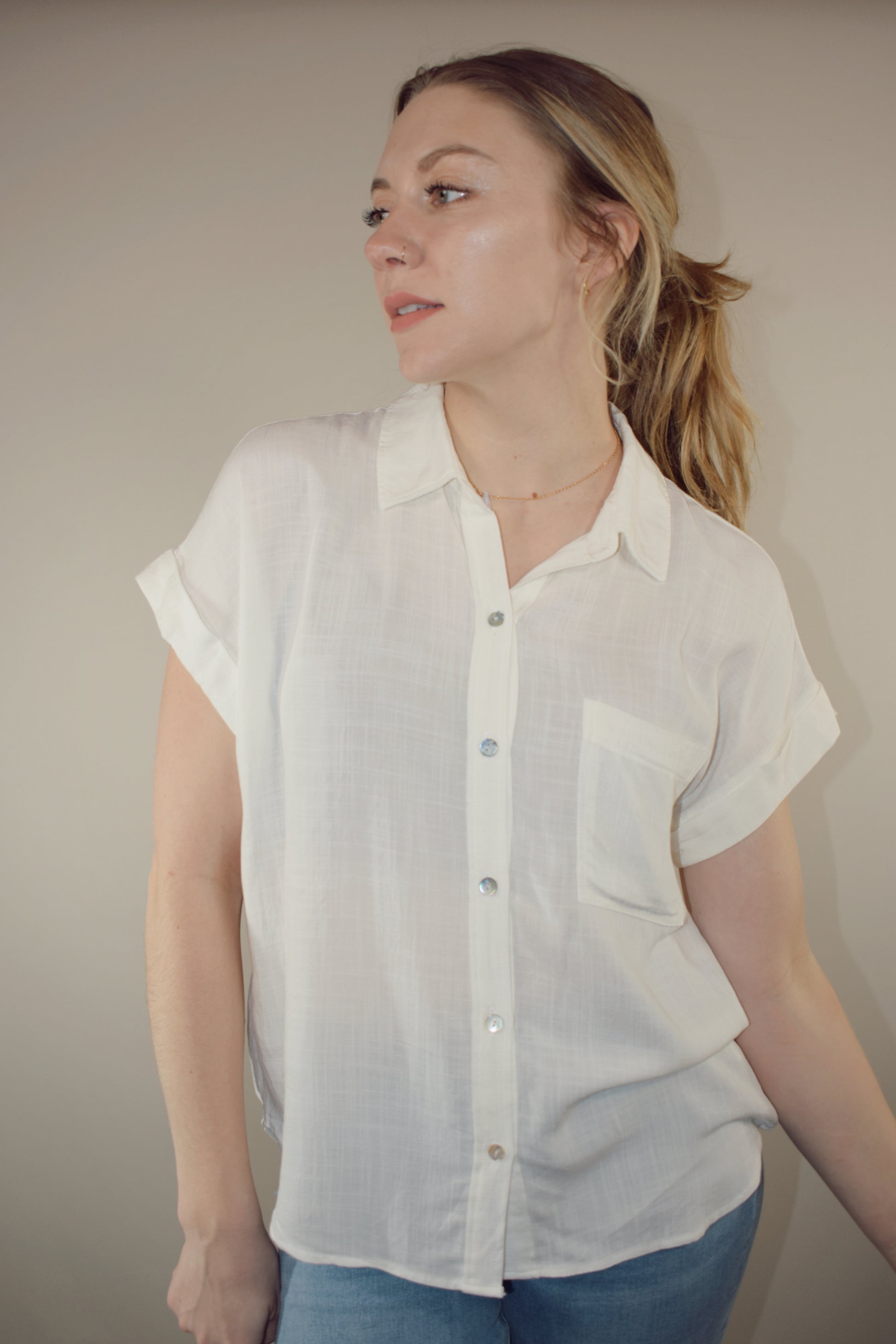 rayon white short sleeve collared button down with cuffed sleeves, one breast patch pocket, loose fit, full length, lightweight.