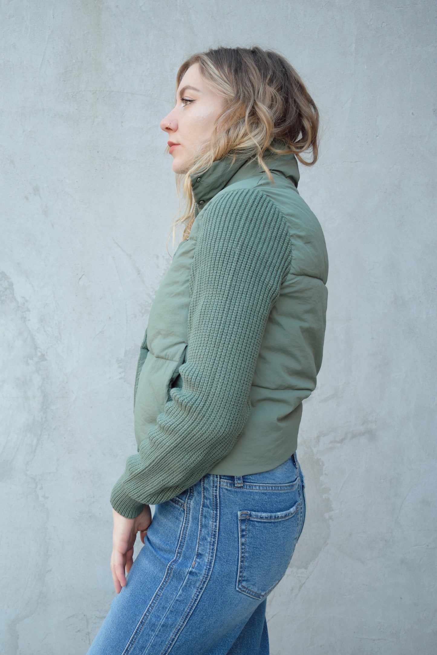 blue green puffer jacket with ribbed knit sleeves, zip and snap front enclosure, has double collar with both materials, has pockets, sinch band at hem